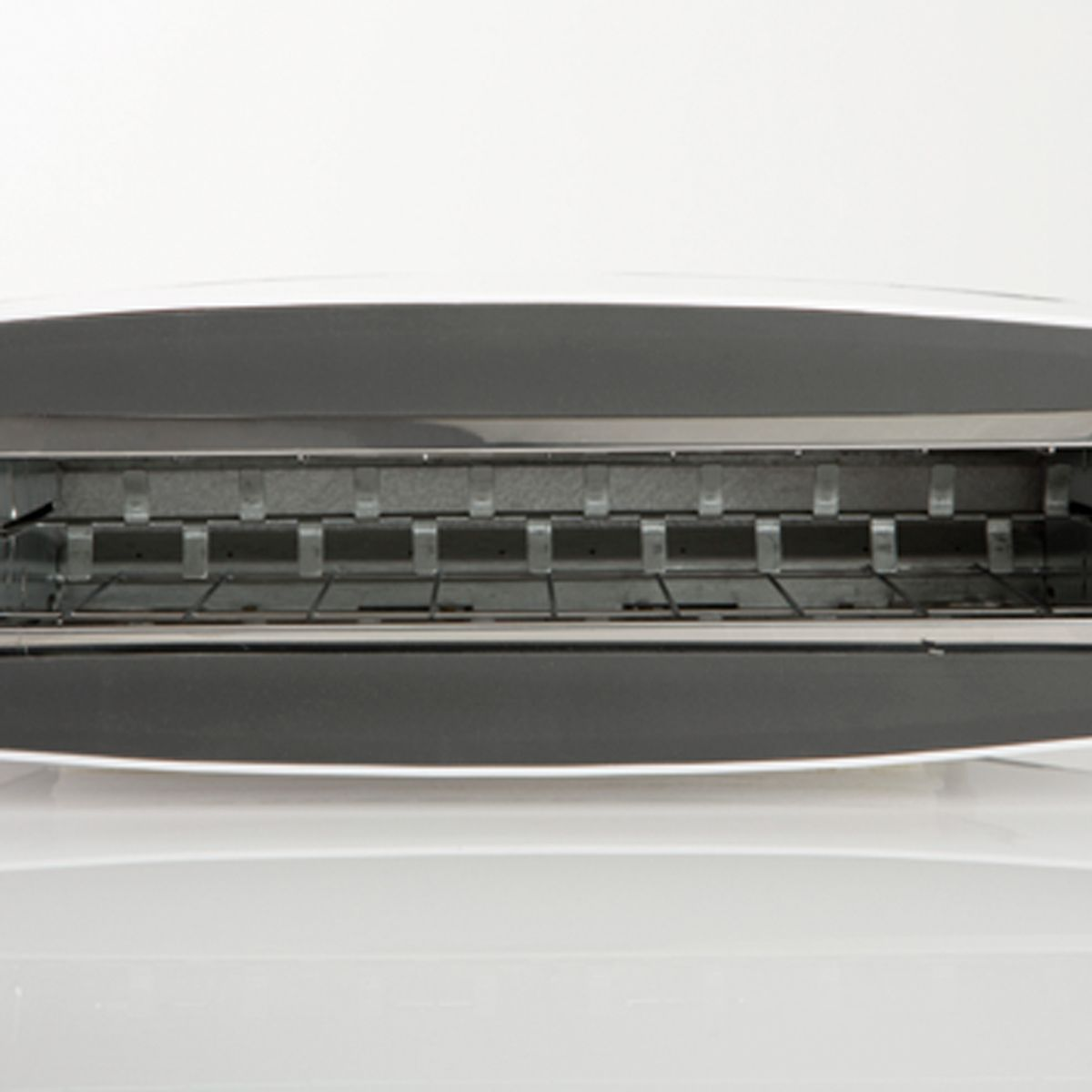 Zbliżenie pokazuje wnętrze tostera. Jest czysty i ma elementy grzewcze.