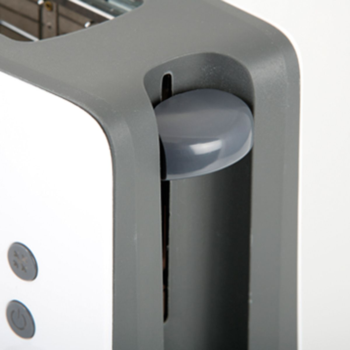 Zbliżenie szarego przycisku na białym i szarym tosterze. Widoczna jest szczelina.