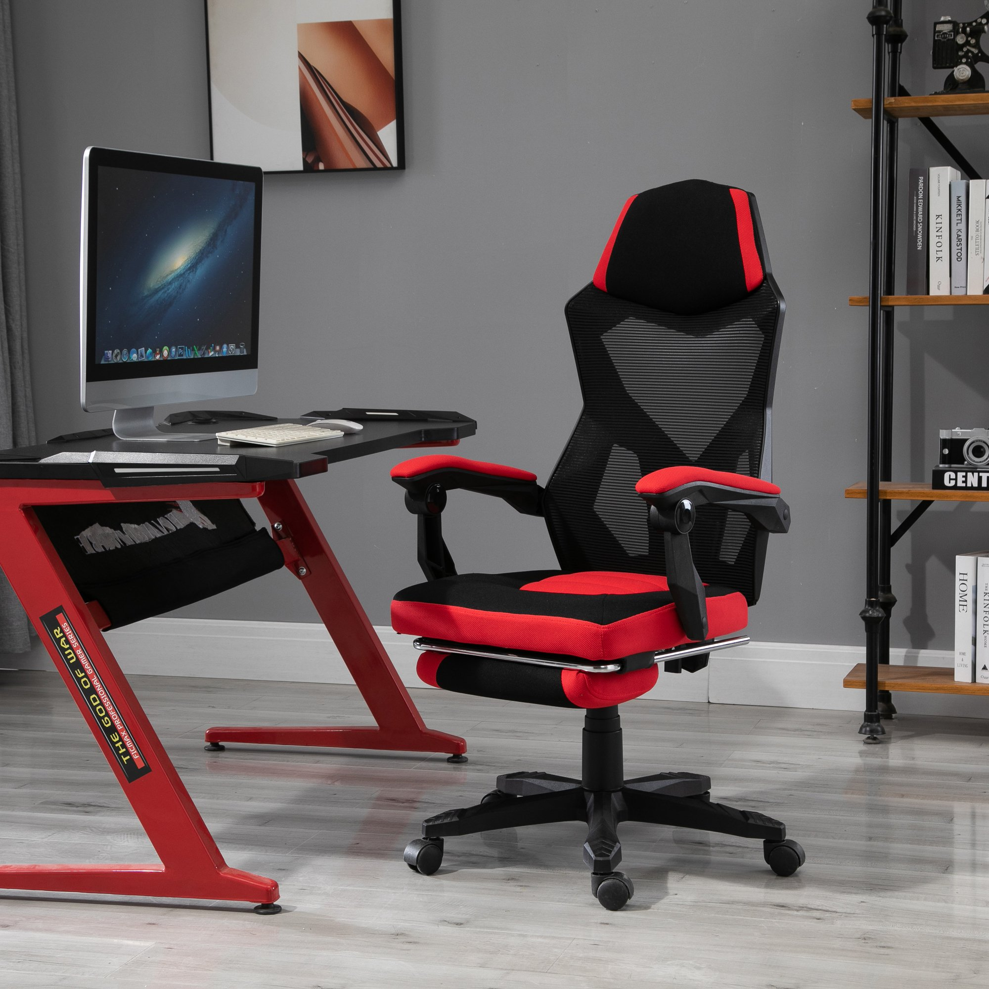 Una silla gamer roja y negra con escritorio y monitor en una habitación.