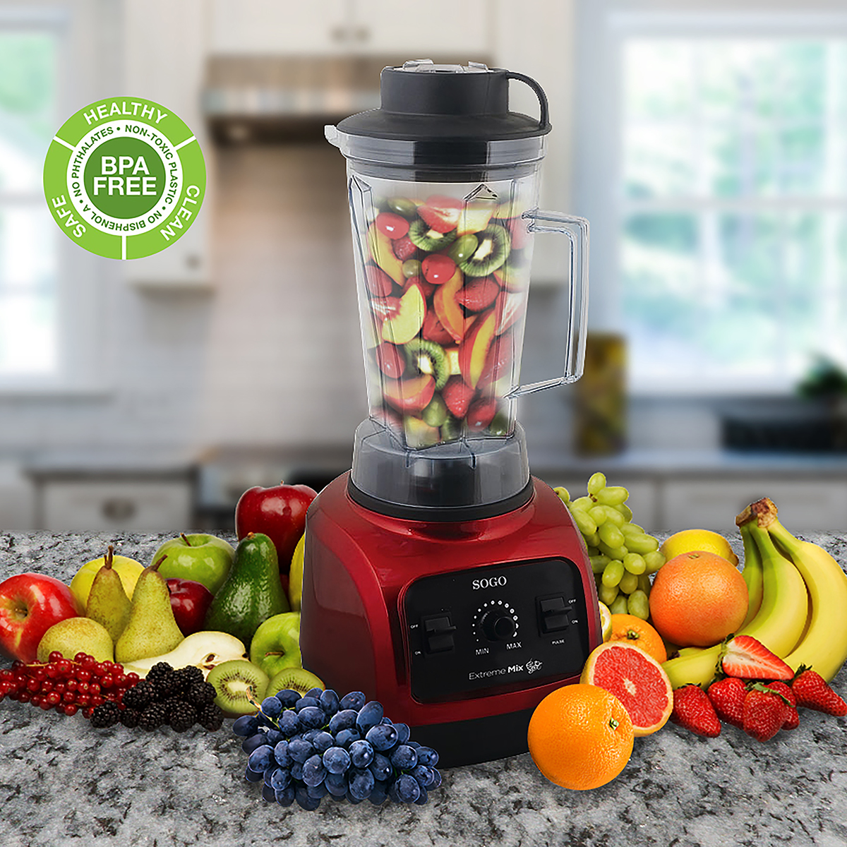 Licuadora roja llena de frutas en una encimera de cocina. Varias frutas rodean la licuadora.