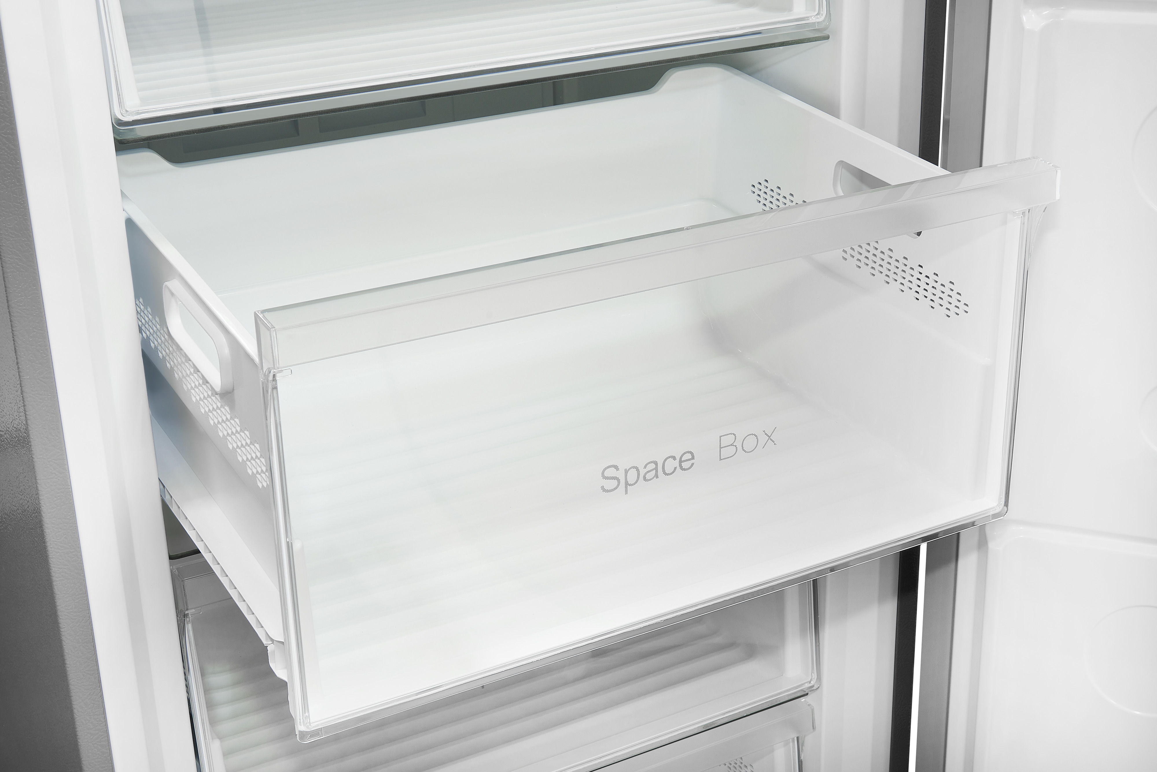Ein Kühlschrankinnenraum mit einer transparenten Schublade mit der Aufschrift 'Space Box'.