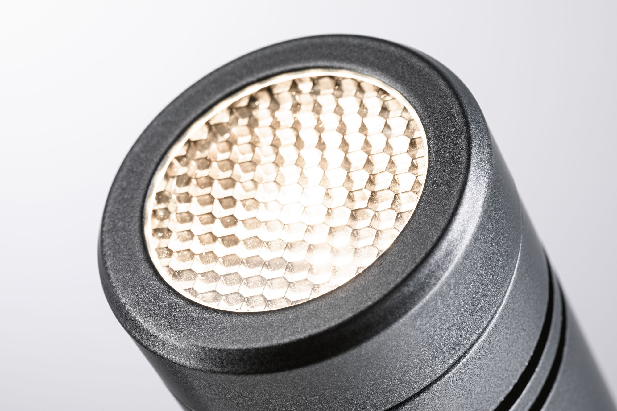 Nahaufnahme eines Scheinwerfers mit Wabenmuster und metallisch-grauem Finish.