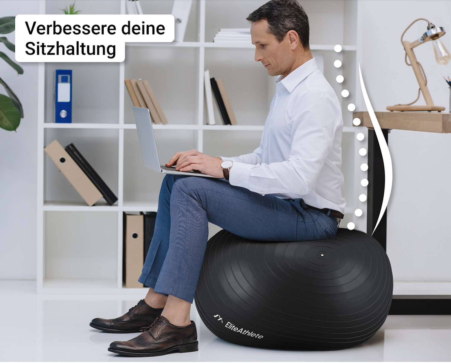 Ein Mann sitzt auf einem schwarzen Gymnastikball und arbeitet im Büro am Laptop.