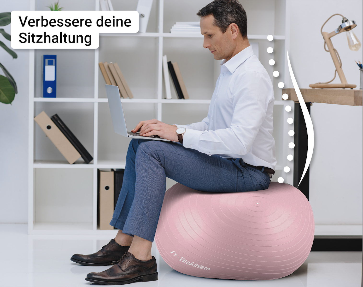 Ein Mann in weißem Hemd und blauer Hose sitzt auf einem rosa Gymnastikball und benutzt einen Laptop im Büro.