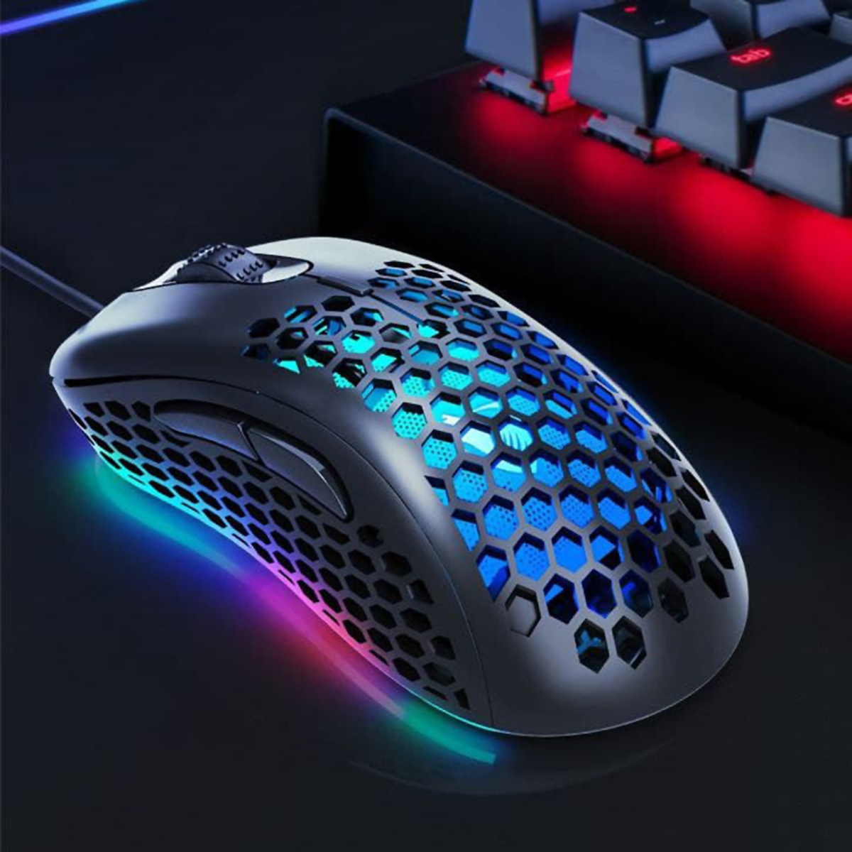 Ratón gaming negro con diseño de panal, iluminación RGB y teclado en el fondo, sobre superficie oscura.