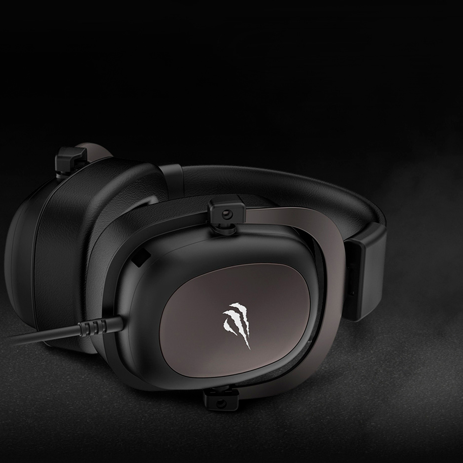 Czarne słuchawki na ciemnej powierzchni. Słuchawki mają logo na nausznikach.