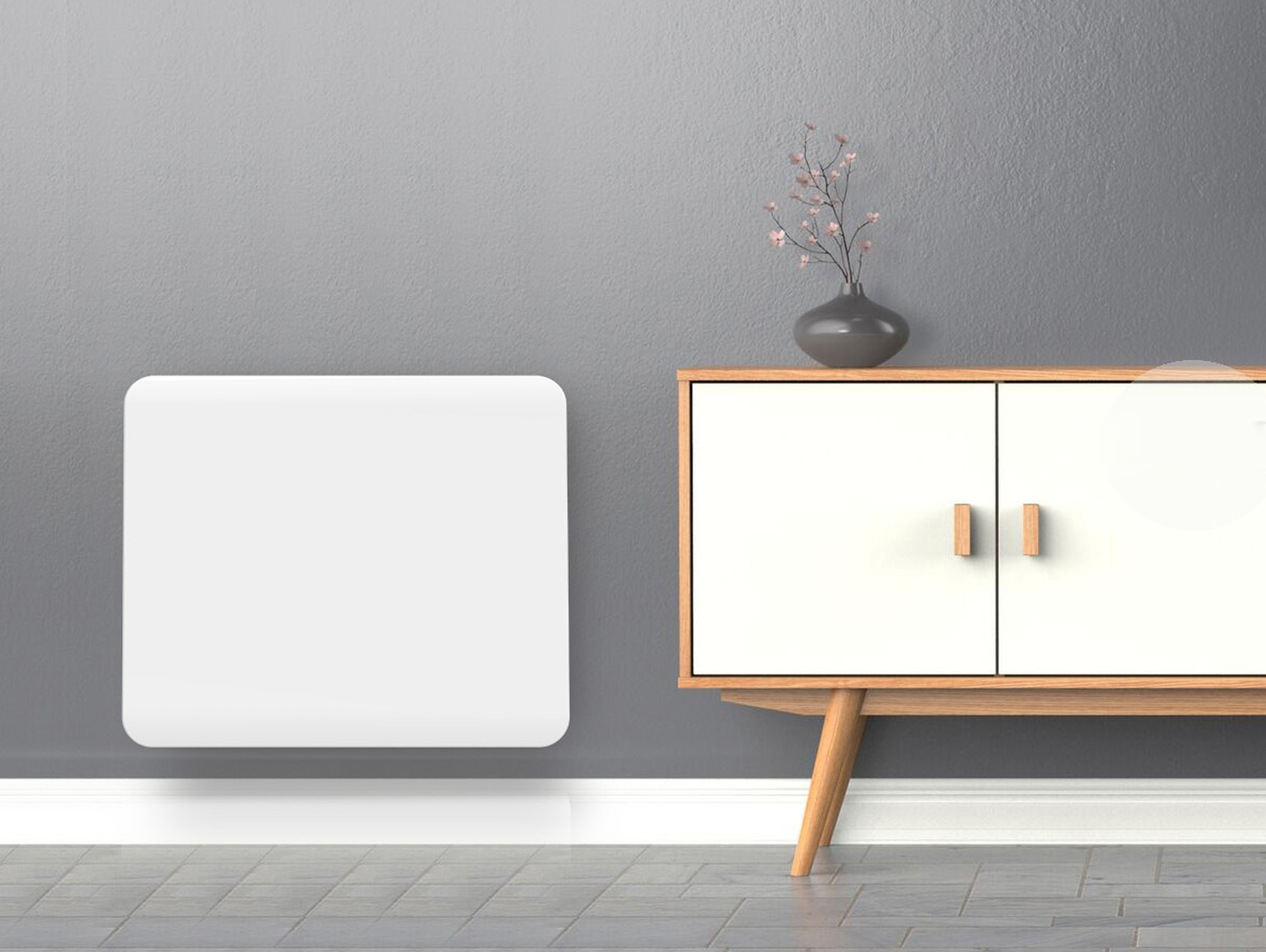 Un calentador blanco montado en la pared con un mueble de madera y un jarrón con flores a la derecha.
