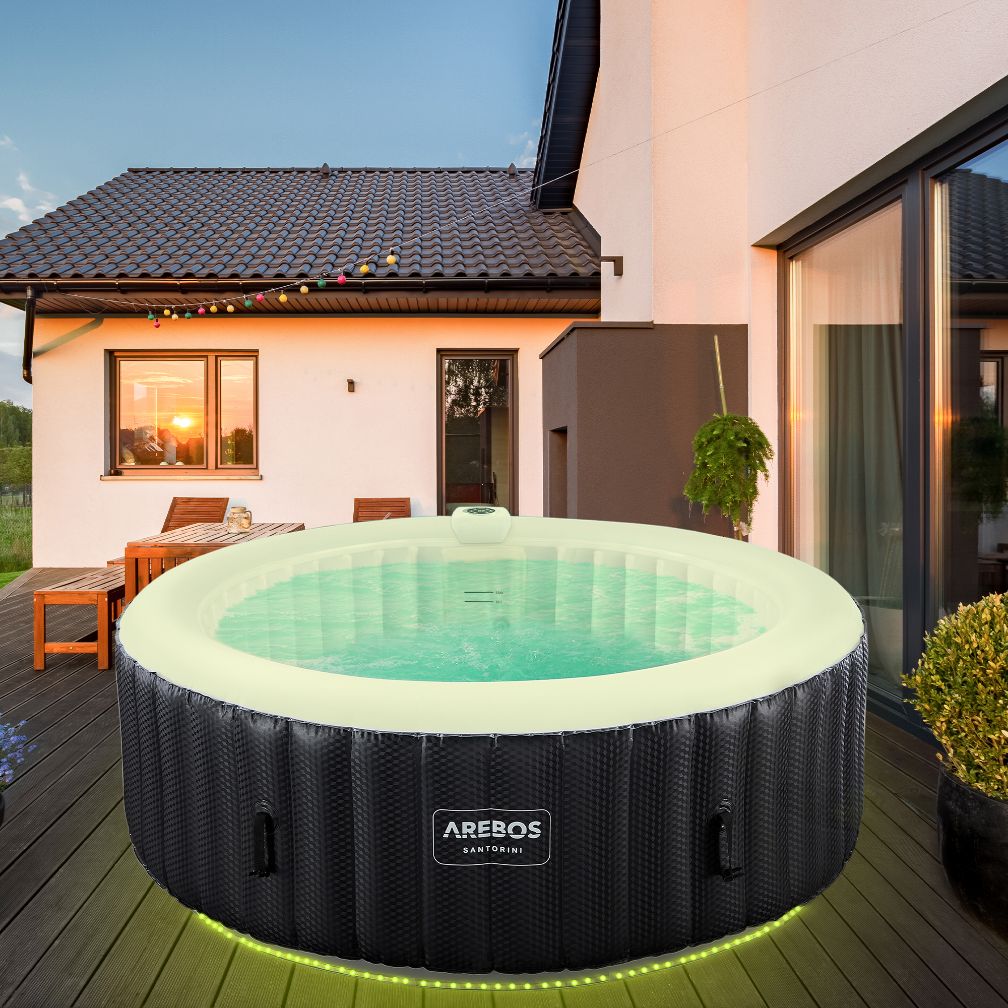 Whirlpool auf einem Holzdeck. Im Hintergrund ein Haus und ein Sonnenuntergang.