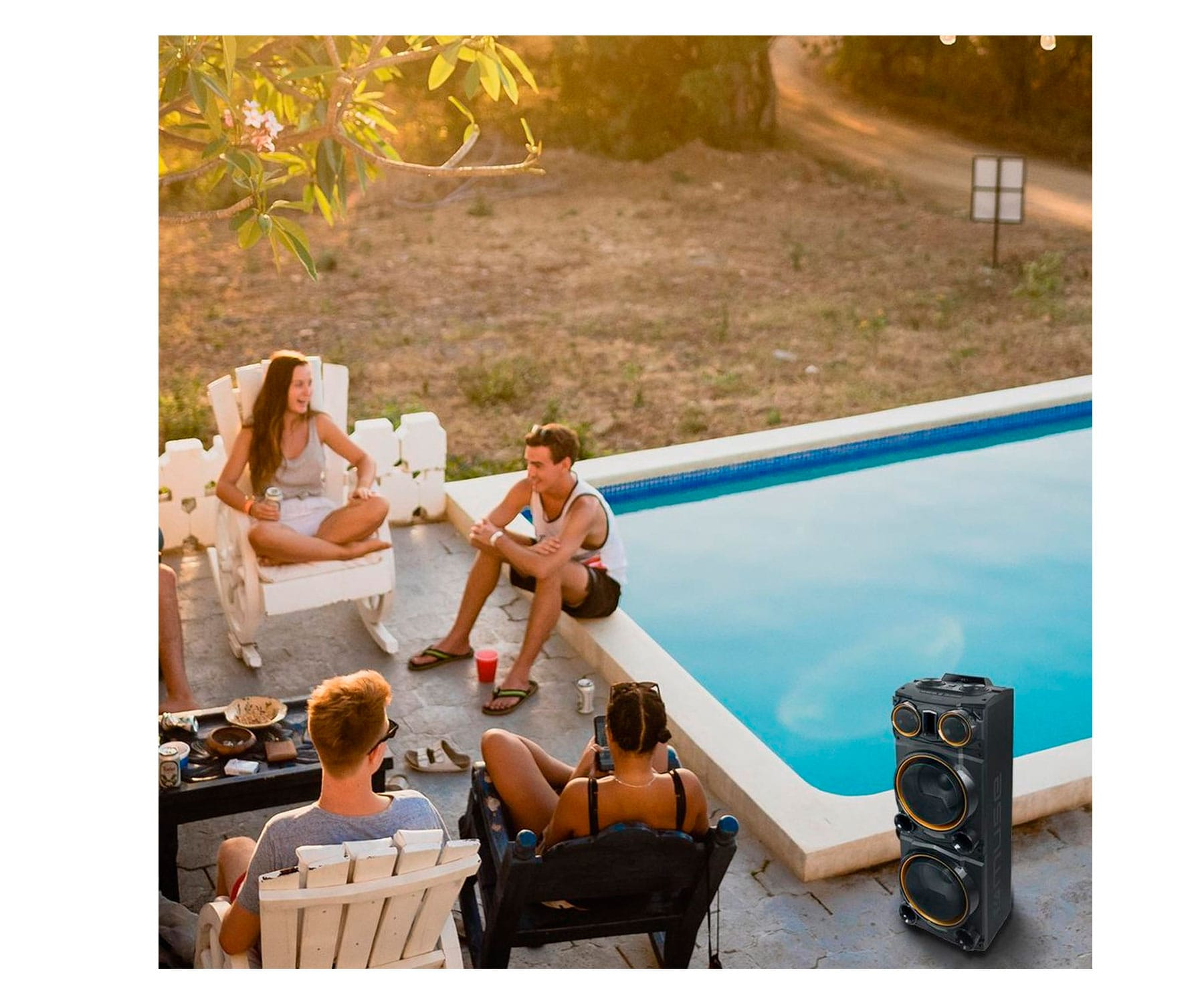Grupa osób na imprezie przy basenie. Duży głośnik stoi przy basenie.