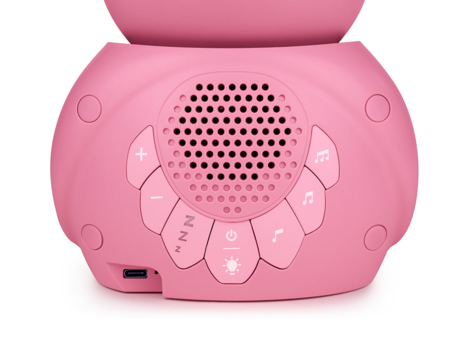 Un altavoz rosa con botones sobre una superficie blanca. El altavoz tiene un puerto USB.
