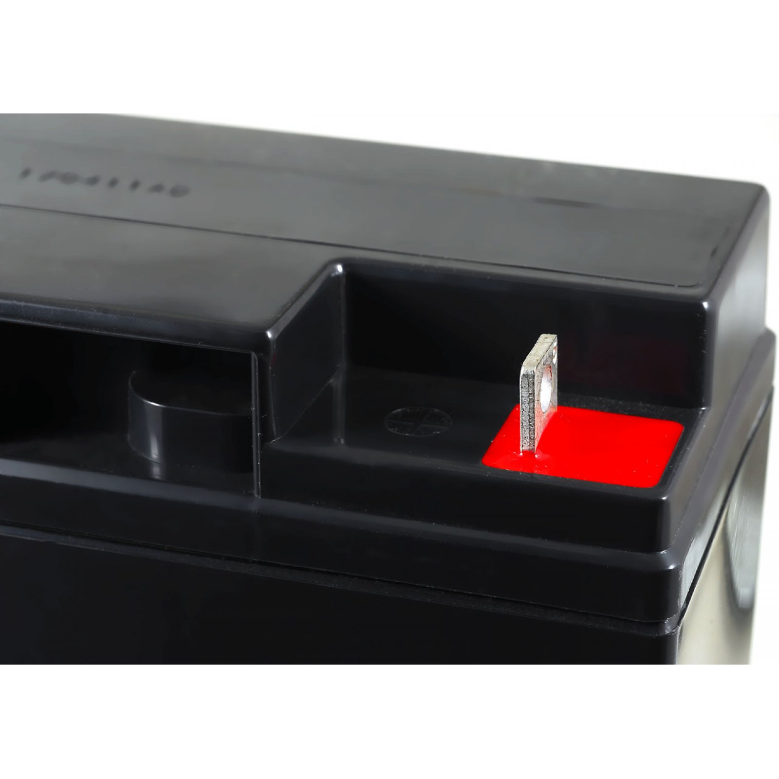 Primer plano de un terminal de batería negro con un cuadrado rojo, sobre un fondo blanco.
