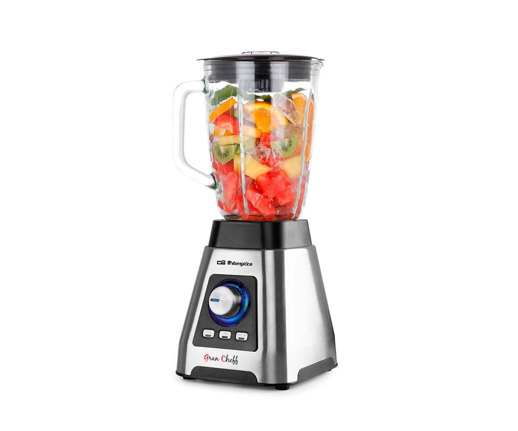 Una licuadora con fruta dentro, sobre una base de acero inoxidable, sobre fondo blanco.