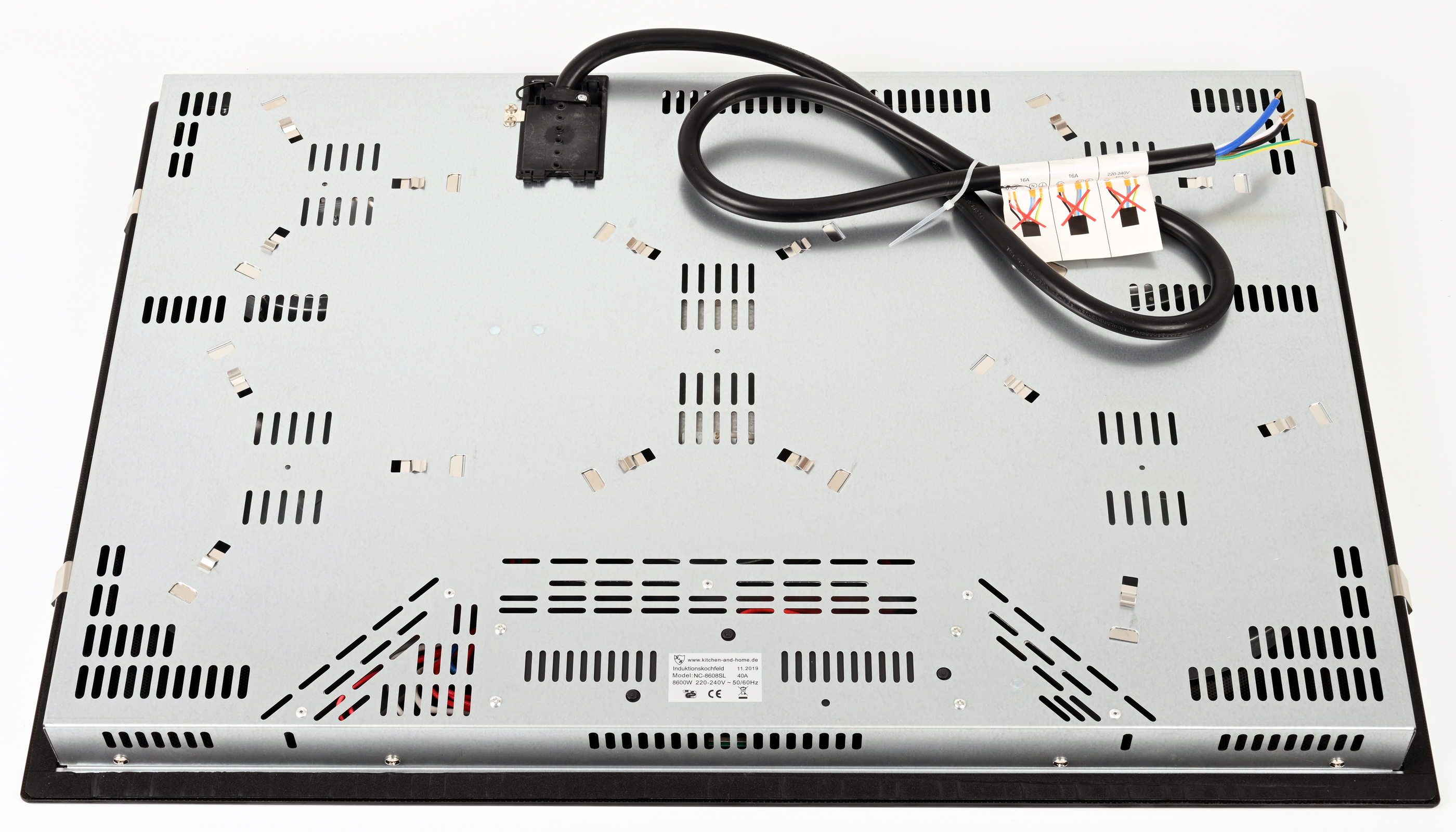Unterseite eines Induktionskochfelds mit schwarzem Netzkabel.