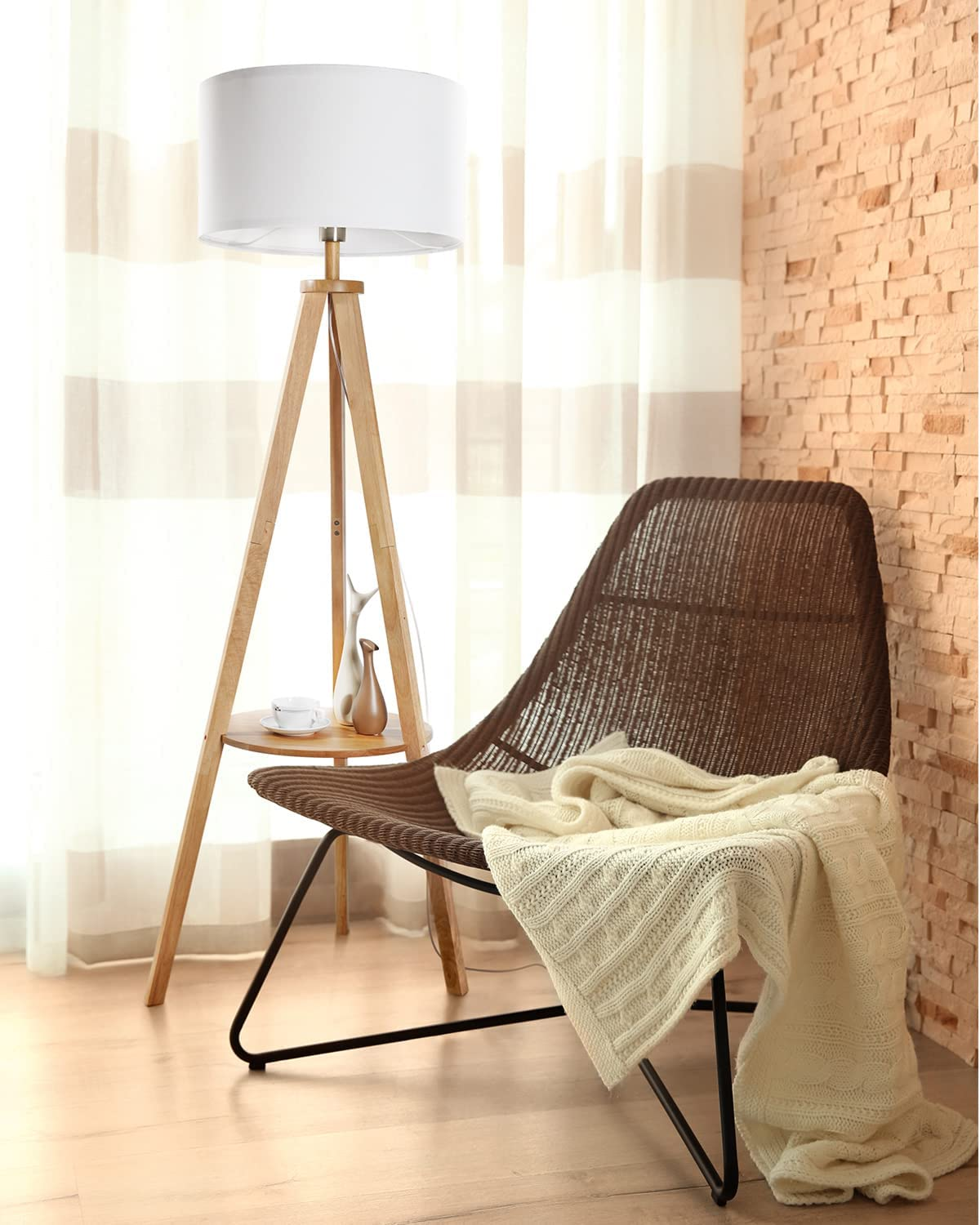 Scena di soggiorno con lampada da terra, sedia e muro di mattoni. Una coperta è sulla sedia.
