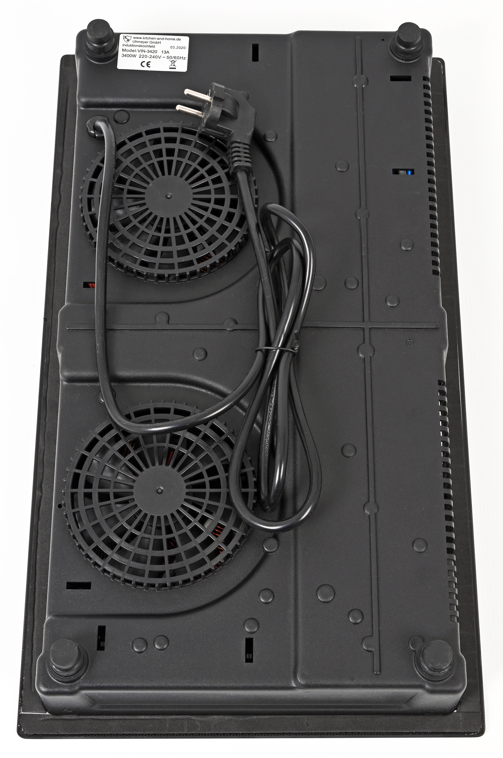 Unterseite eines Induktionskochfelds mit zwei Ventilatoren und Netzkabel.