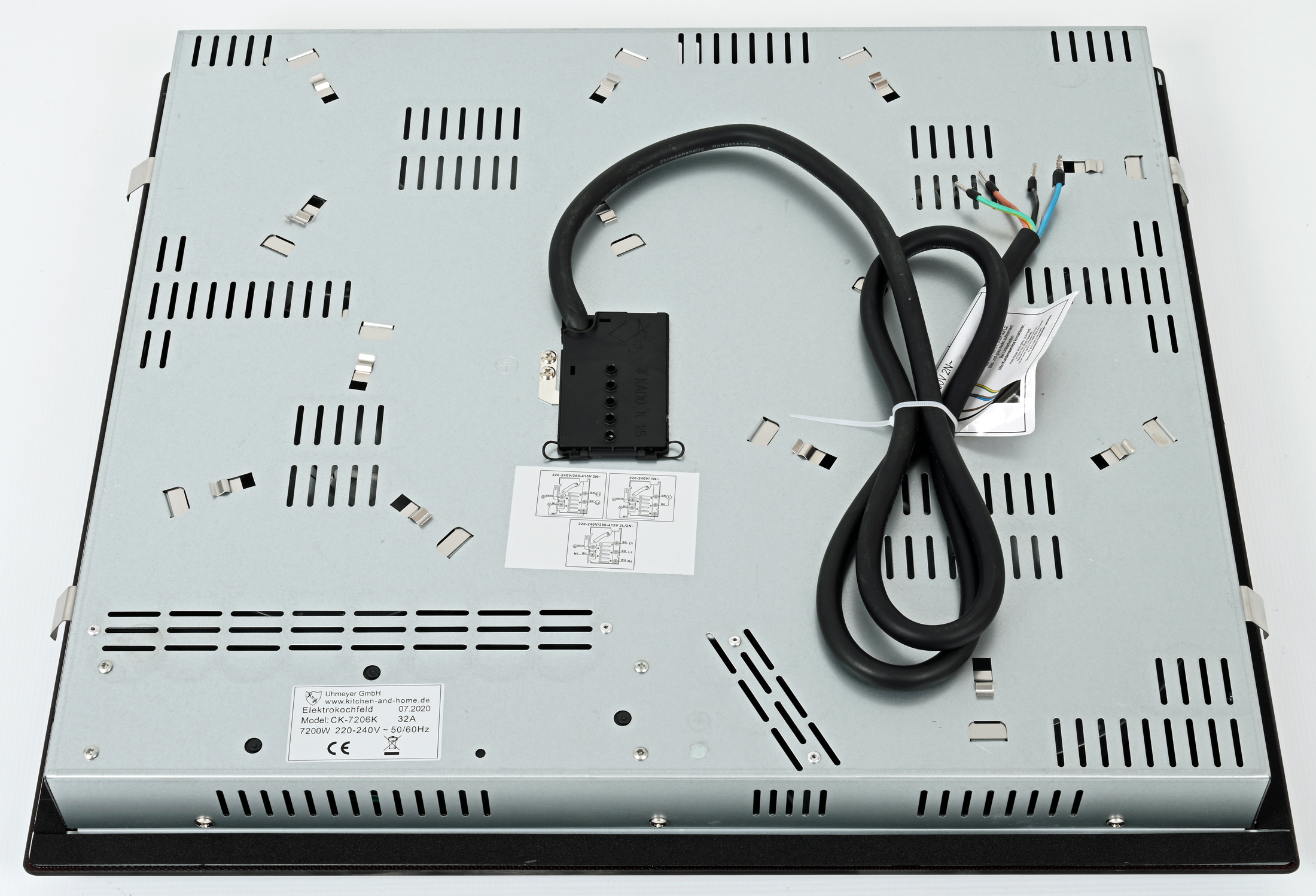 Die Rückseite eines Induktionskochfelds mit Netzkabel und verschiedenen Lüftungslöchern.