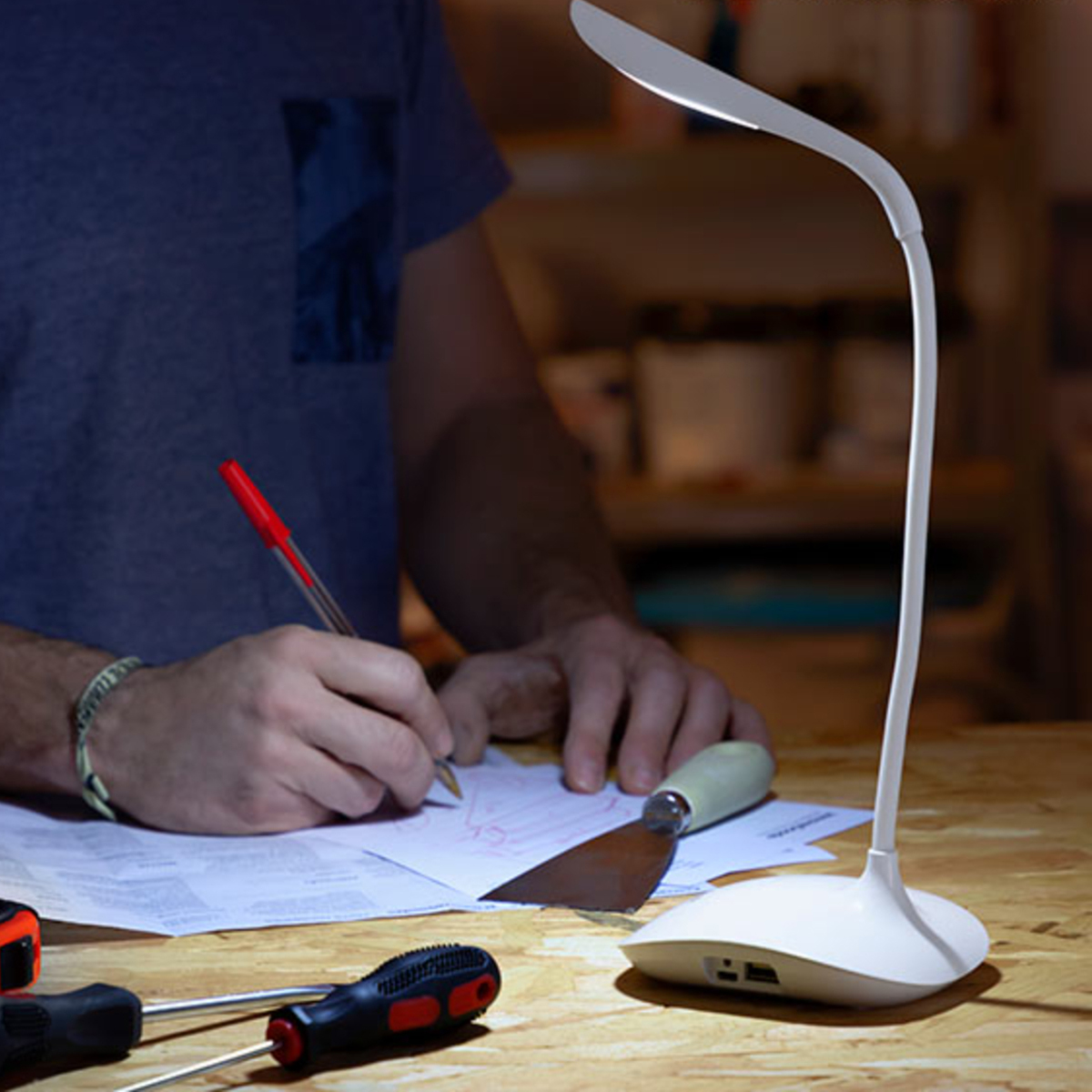 Una lampada da scrivania che fornisce luce a una persona che scrive su carta.
