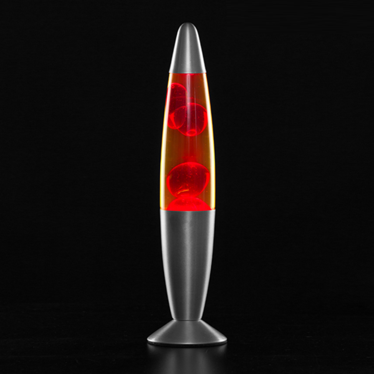 Lámpara de lava con burbujas rojas en líquido naranja, base y parte superior plateadas, fondo negro.