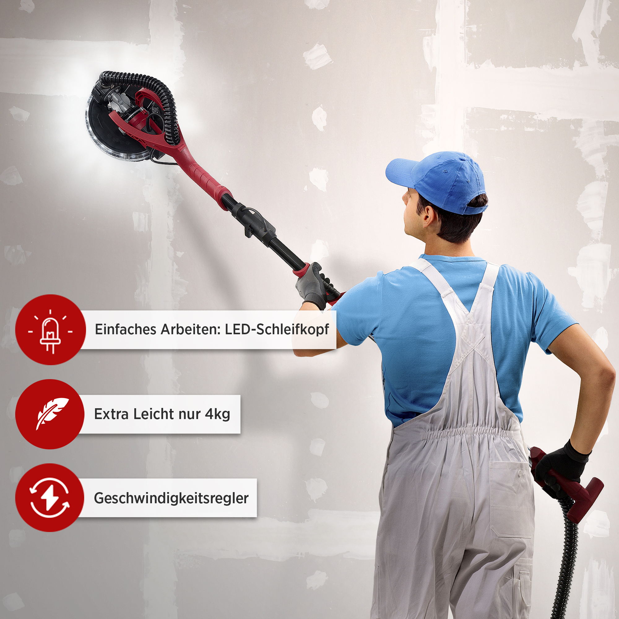 Ein Mann, der ein Schleifwerkzeug an einer Wand benutzt. Das Werkzeug ist rot und schwarz, der Mann trägt eine blaue Kappe.
