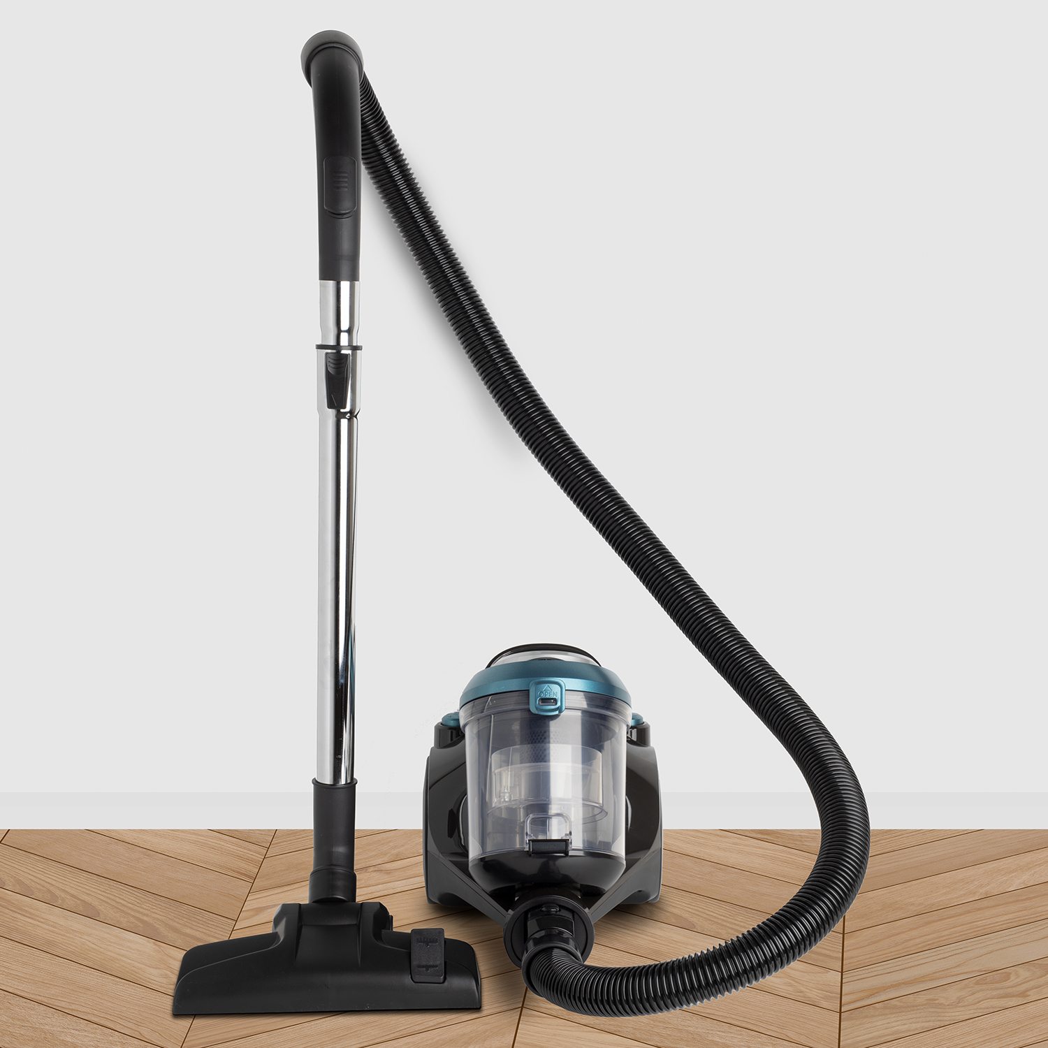 Odkurzacz z wężem na drewnianej podłodze, tło białej ściany.