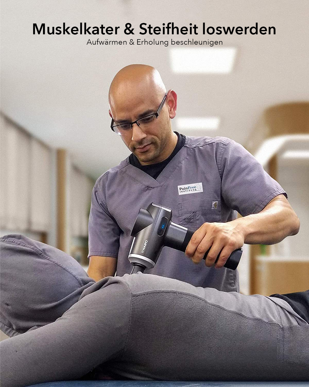 Ein Mann in grauer Uniform massiert mit einer Massagepistole den Rücken einer Person.