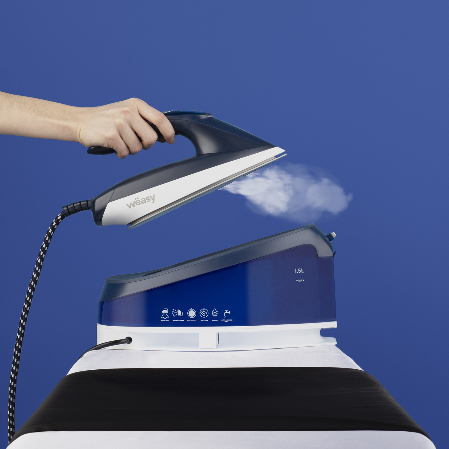 Eine Person benutzt ein blau-graues Dampfbügeleisen. Das Bügeleisen dampft über einer blauen Basis. Der Hintergrund ist blau.