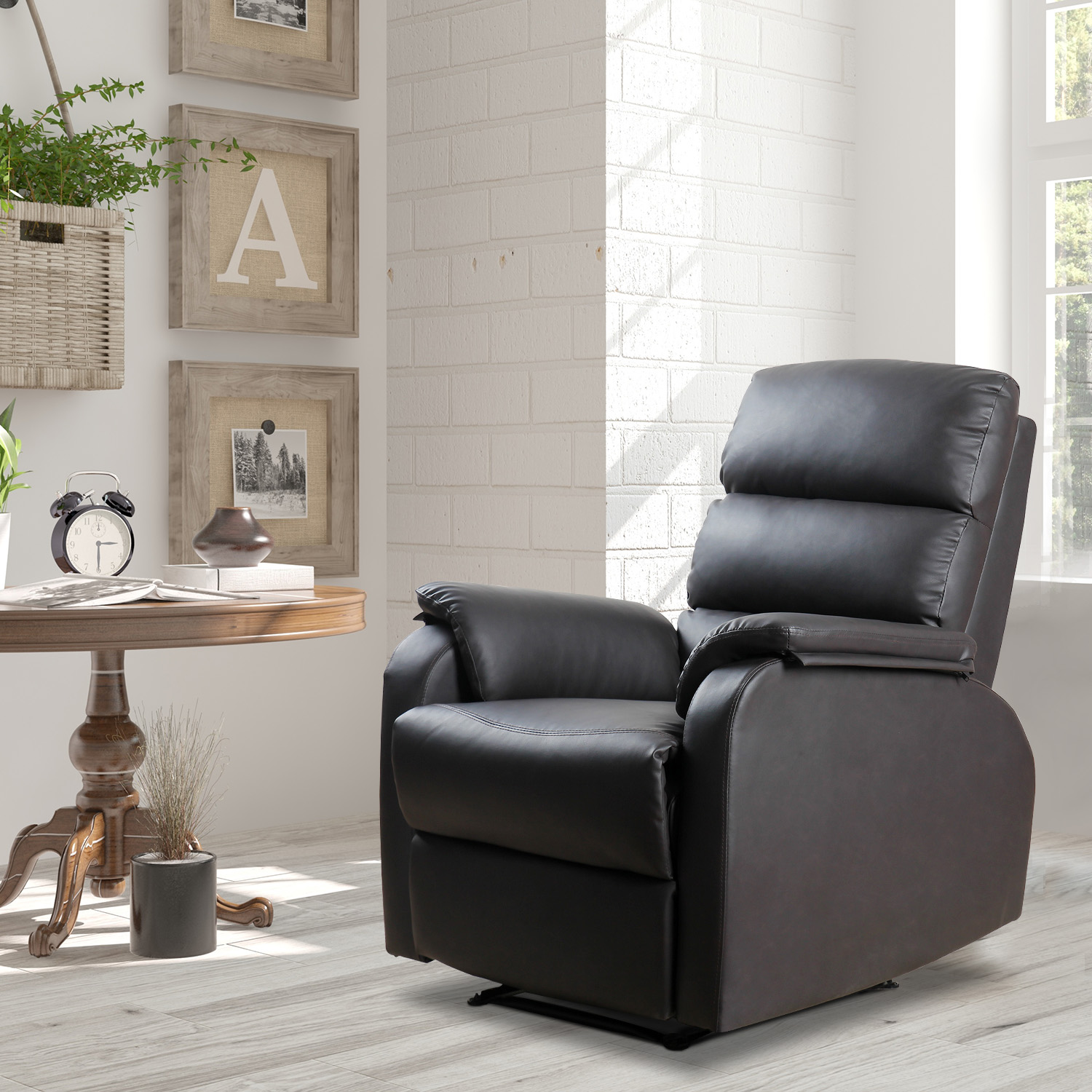 Un sillón reclinable de cuero negro en una habitación bien iluminada con pared de ladrillo y mesa de madera.