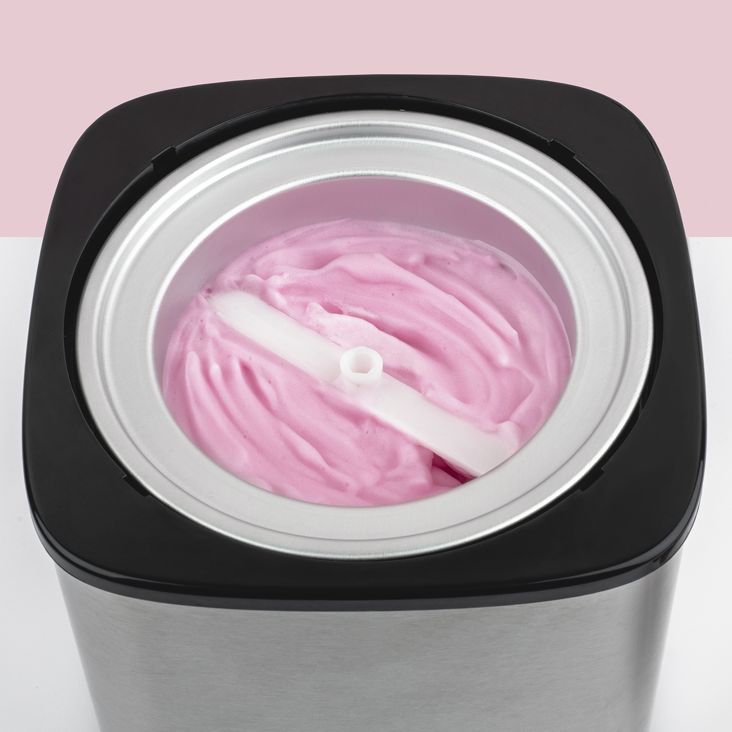 Maszyna do lodów z różowymi lodami i białą łopatką.