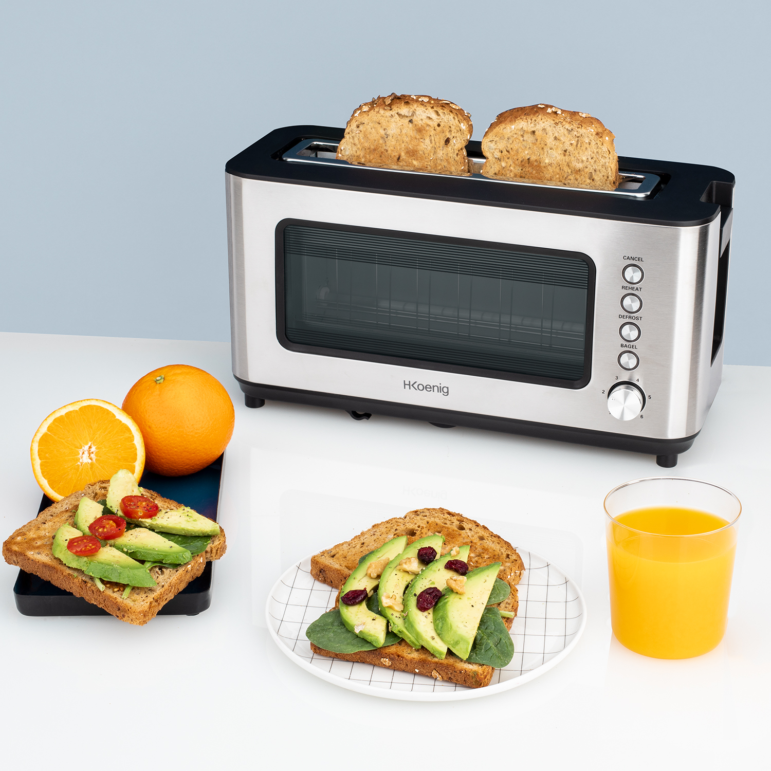 Tostapane con due fette di pane e due toast di avocado con succo d'arancia. Su sfondo bianco.