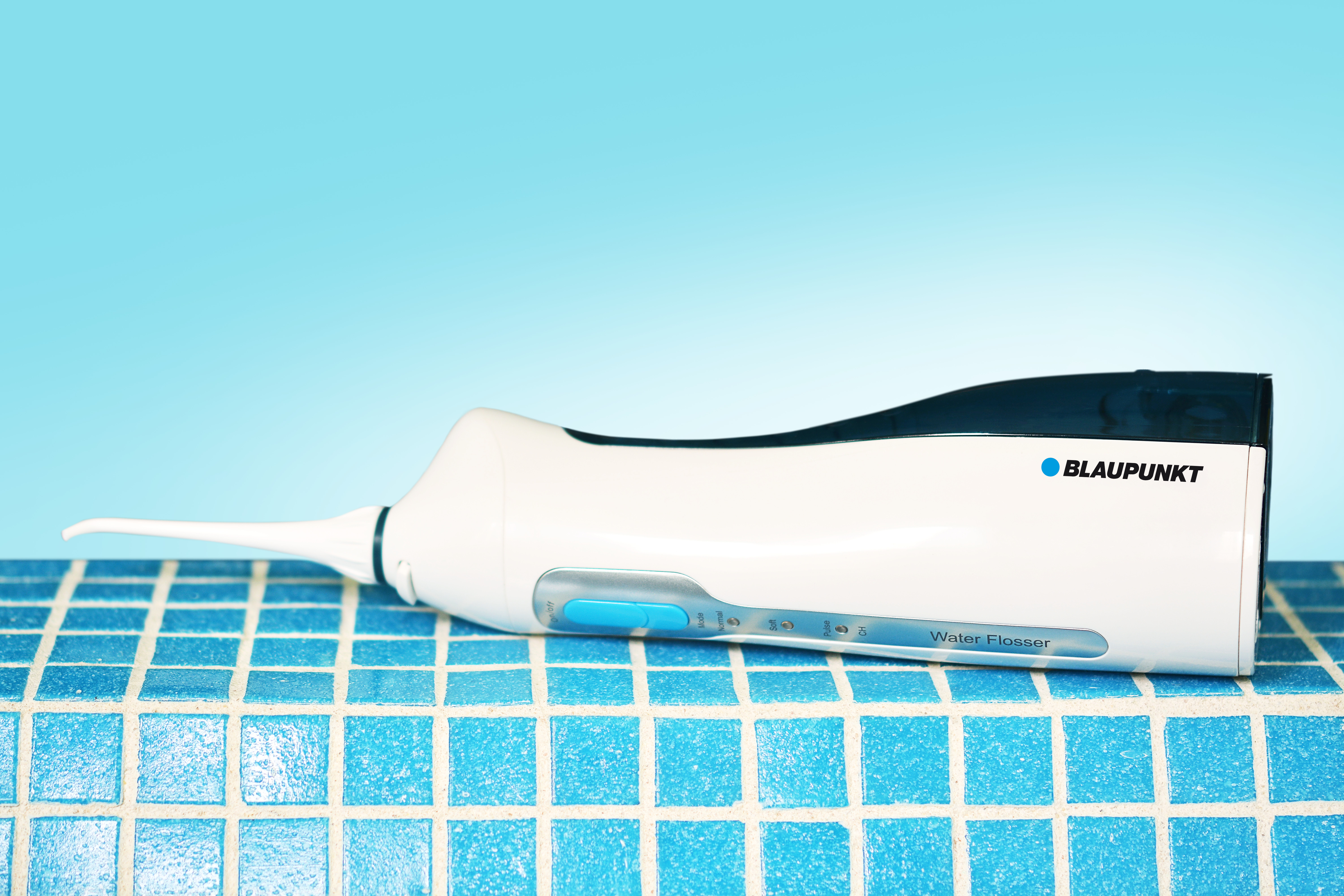 Idropulsore bianco e blu su una superficie piastrellata. Il marchio BLAUPUNKT è visibile.