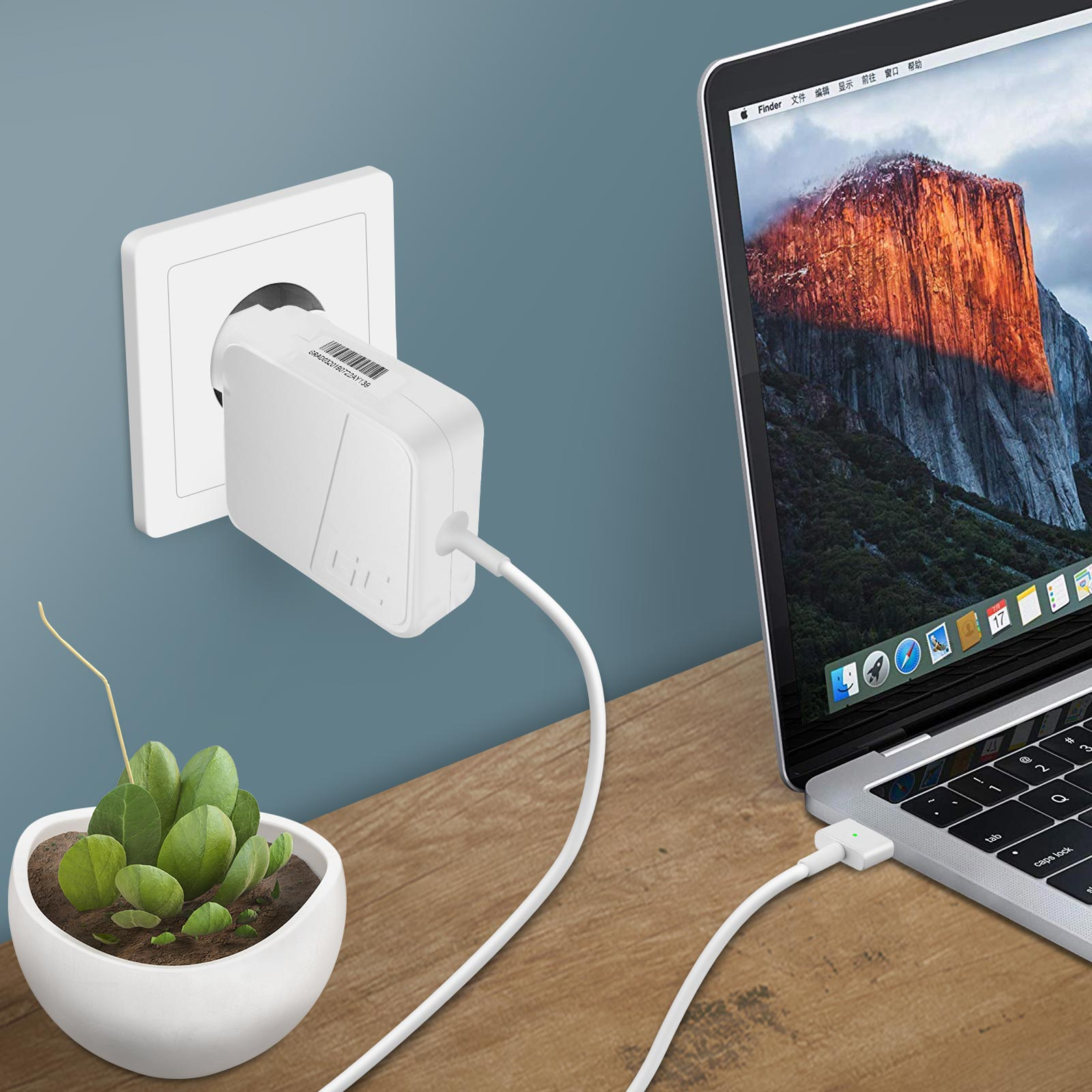 Adattatore di alimentazione bianco collegato a una presa a muro, con laptop e pianta.