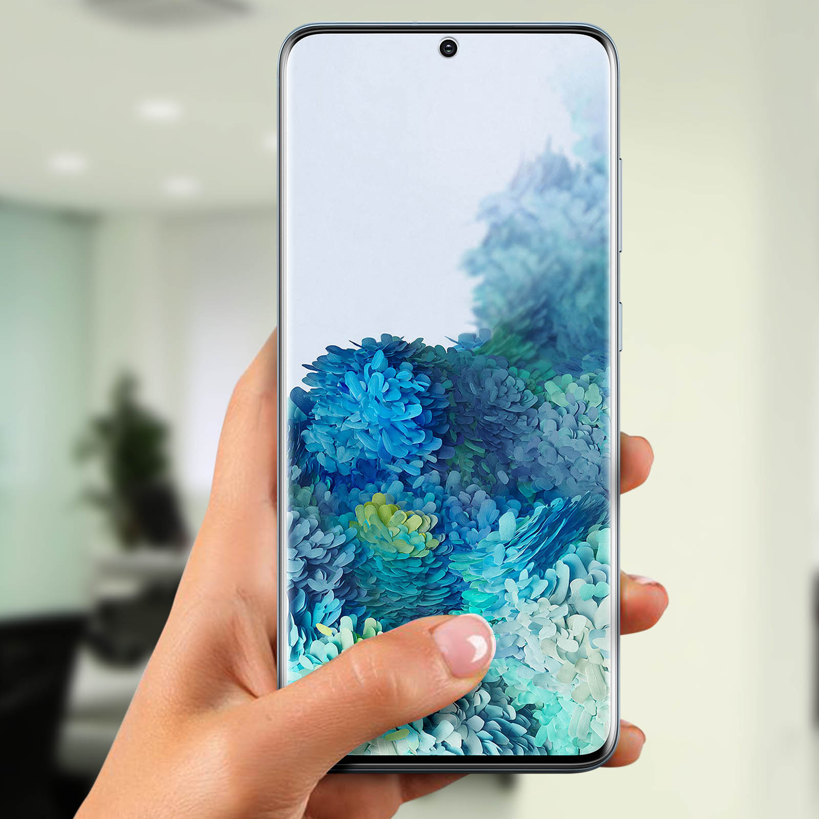 Una mano tiene un telefono che mostra arte floreale blu. Il dito tocca lo schermo. Lo sfondo è sfocato.