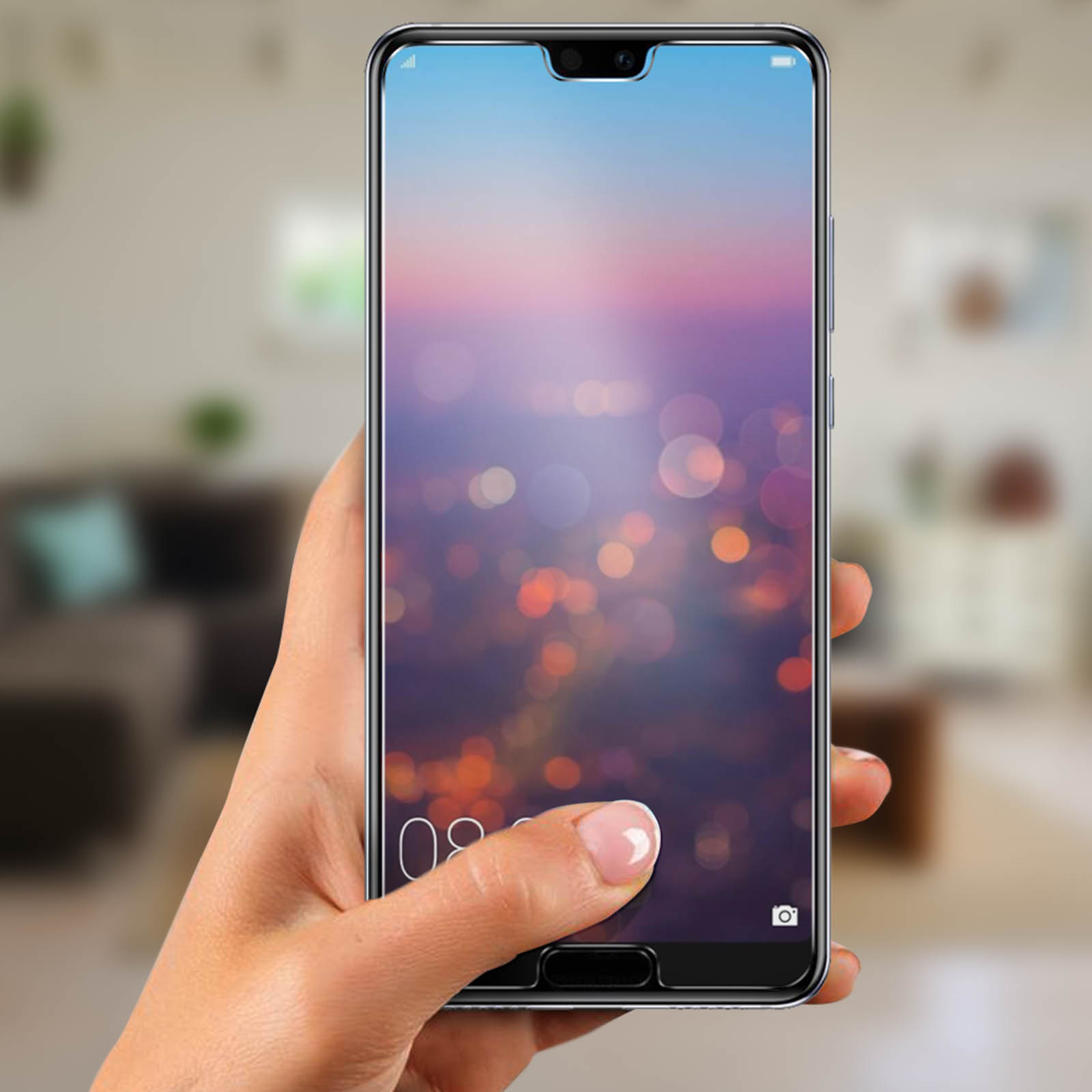 Mano che tiene un telefono con protezione schermo. Il telefono mostra uno sfondo sfocato di luci cittadine.