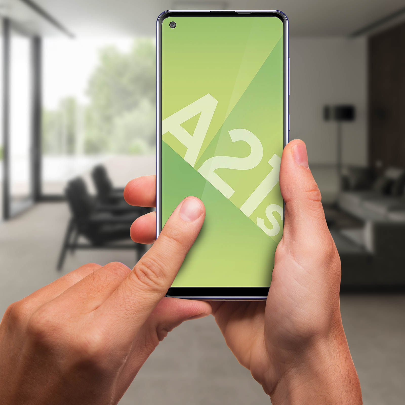 Mani che tengono un telefono con A21s su sfondo verde. Il telefono è a fuoco. Lo sfondo è una stanza sfocata.