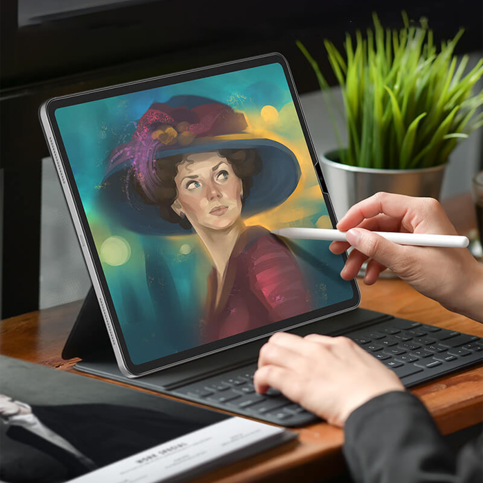 Persona che usa uno stilo su un tablet che mostra un dipinto di ritratto, tastiera sotto.