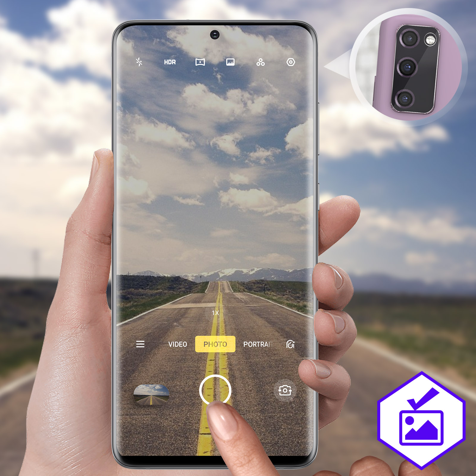 Une personne tenant un téléphone avec une photo de route à l'écran. Une interface de caméra est visible.