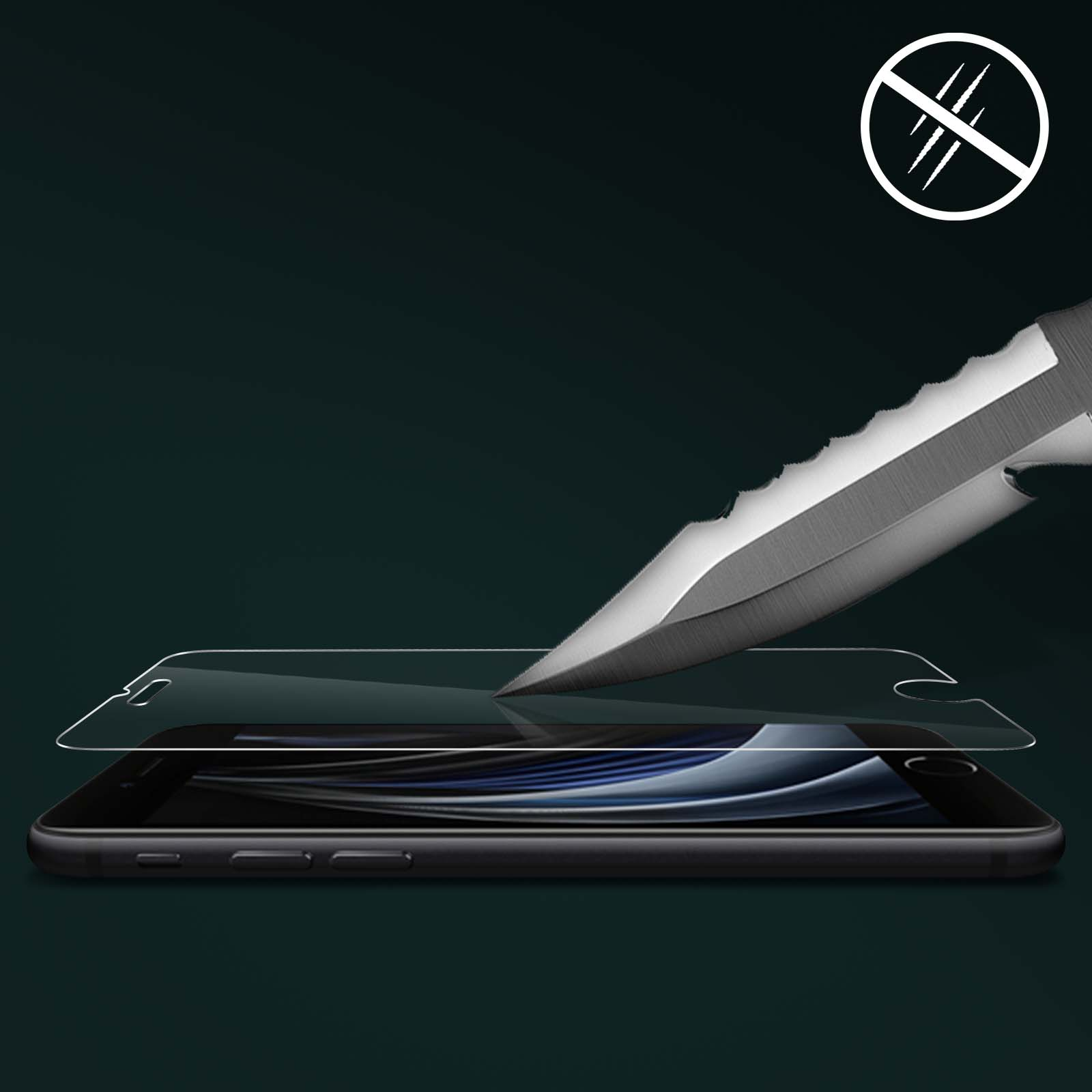 Un coltello sta tagliando una protezione per lo schermo sopra un telefono. Lo sfondo è scuro.
