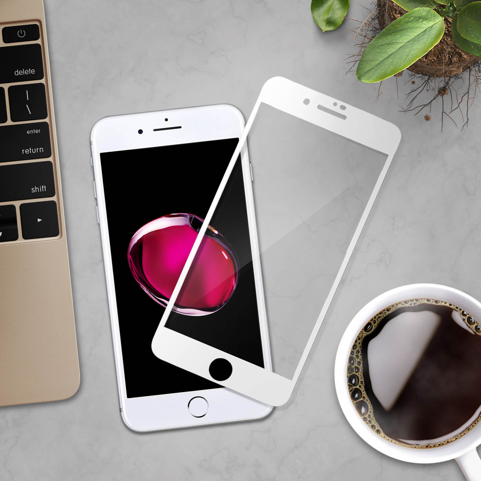 Witte iPhone met schermbeschermer, op grijze ondergrond met koffiekopje en plant. Laptoptoetsenbord links.