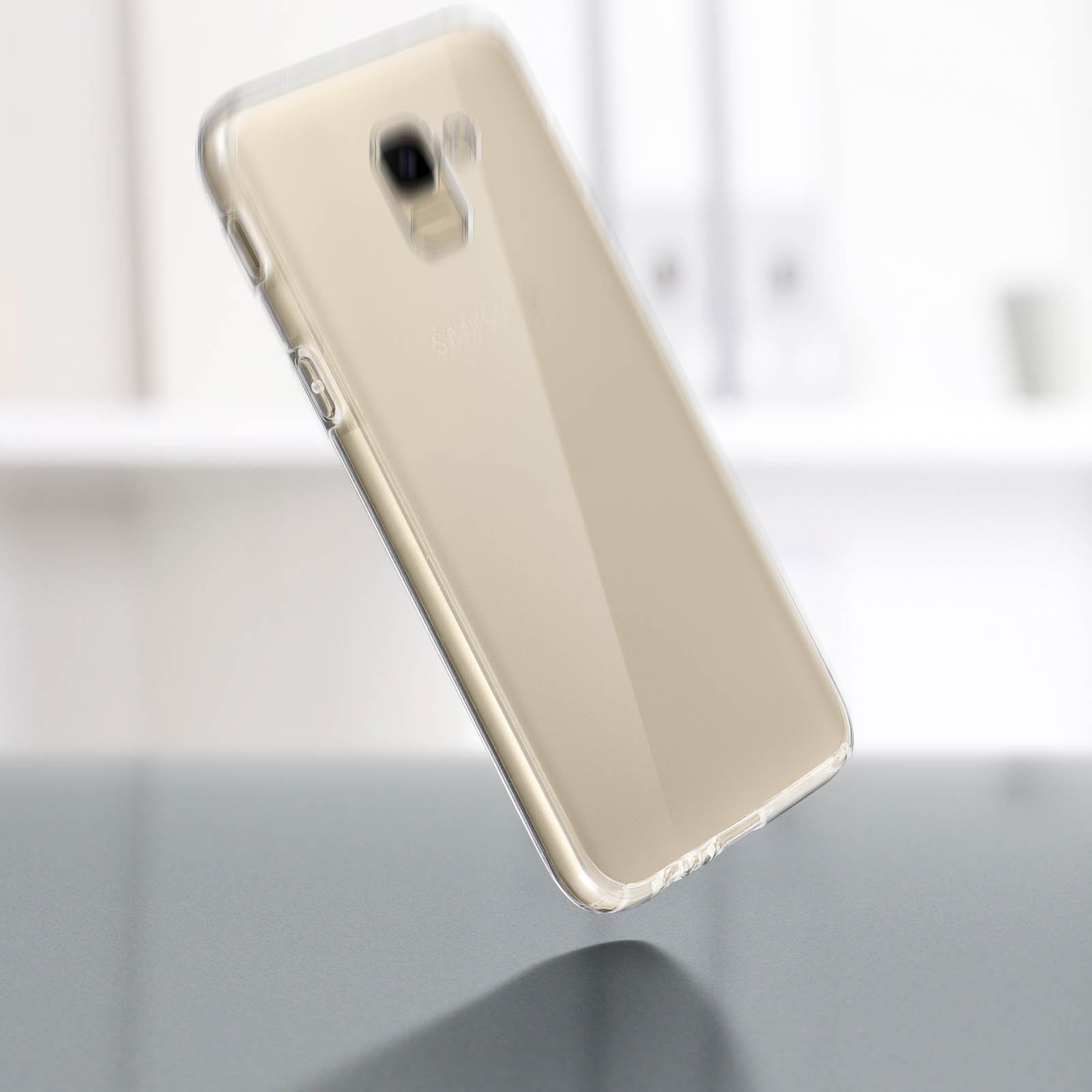 Un telefono in una custodia trasparente. Il telefono è color oro e si trova su un tavolo.
