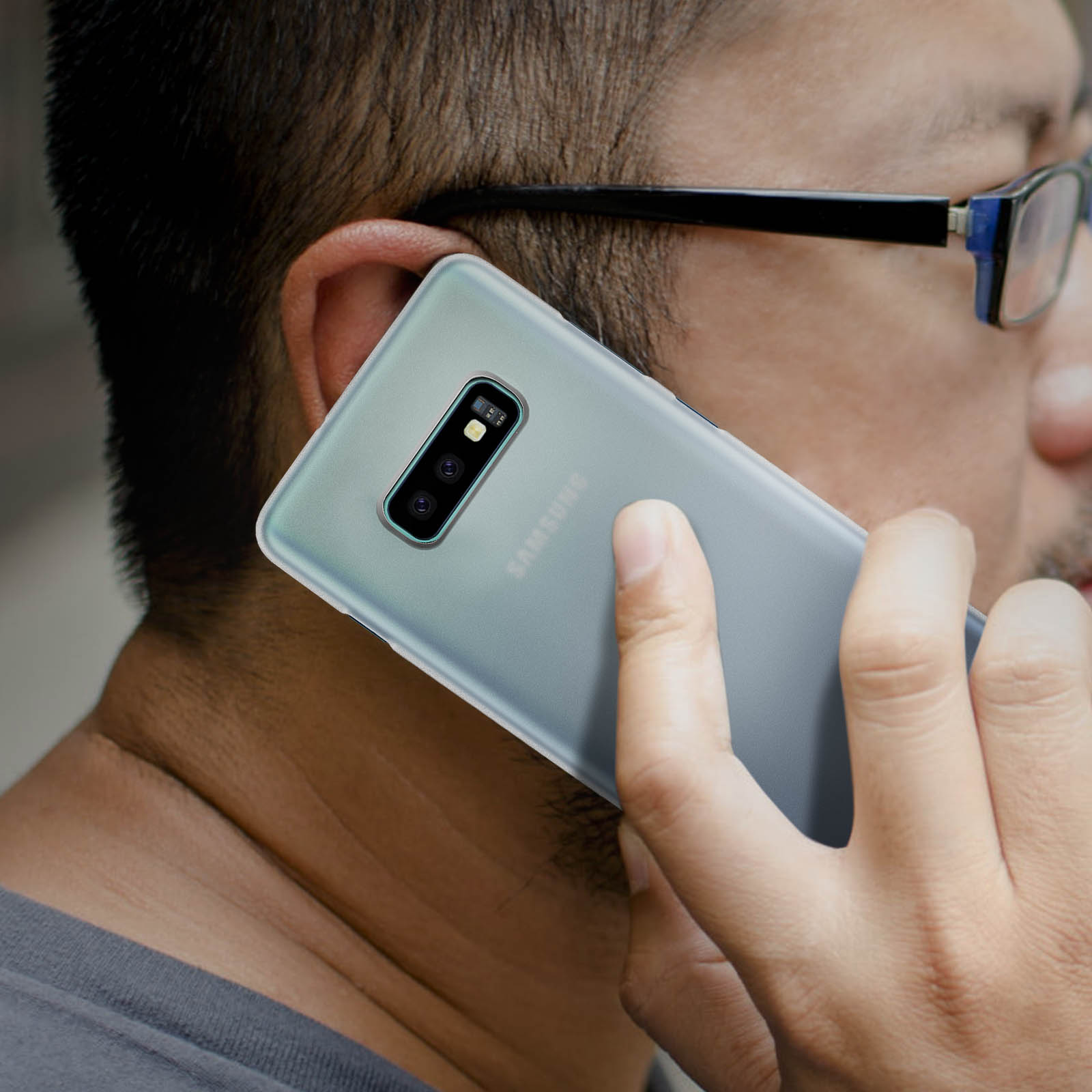 Una persona che tiene un telefono all'orecchio, mostrando il retro del telefono.