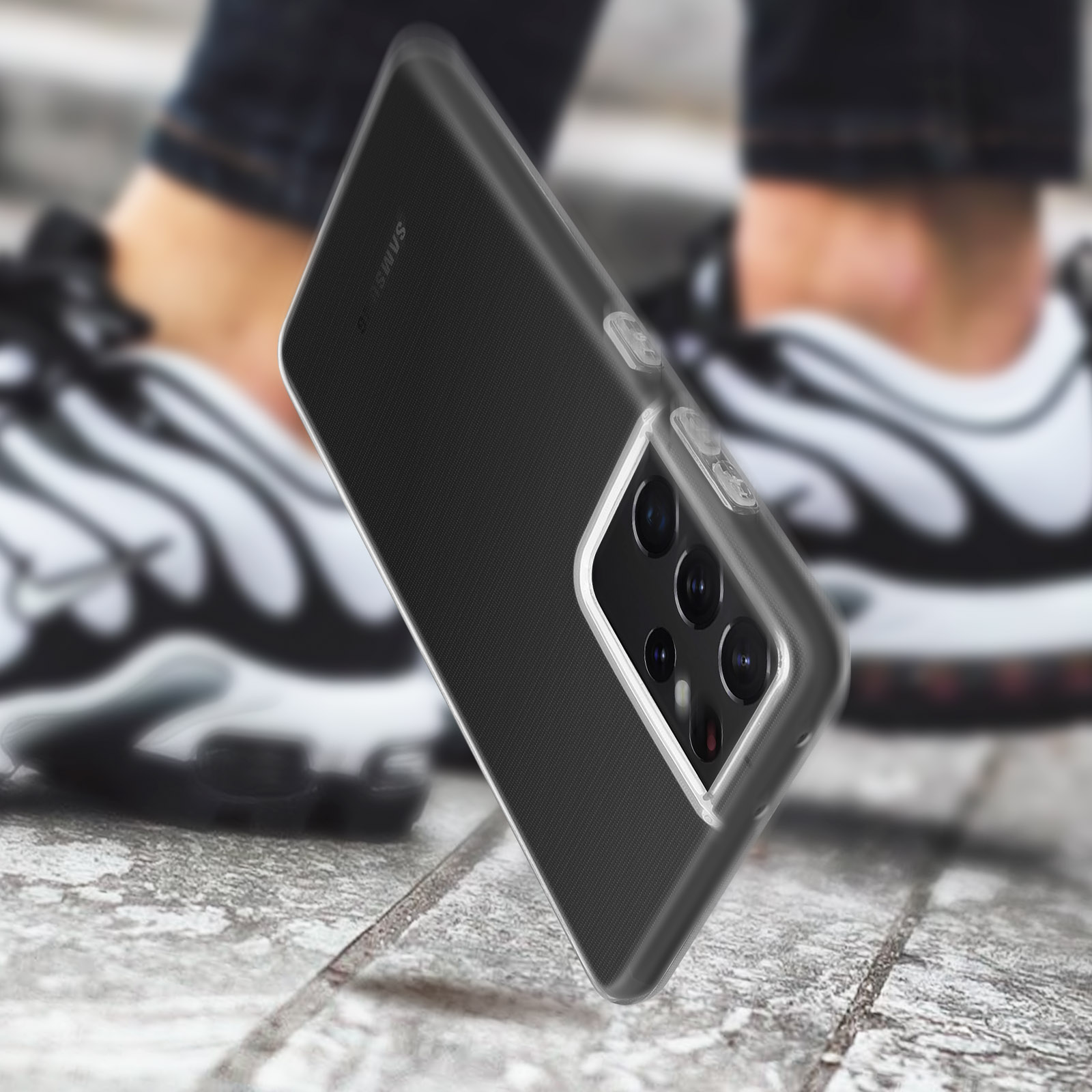 Coque de téléphone transparente sur un téléphone. Arrière-plan flou avec jambes et baskets.