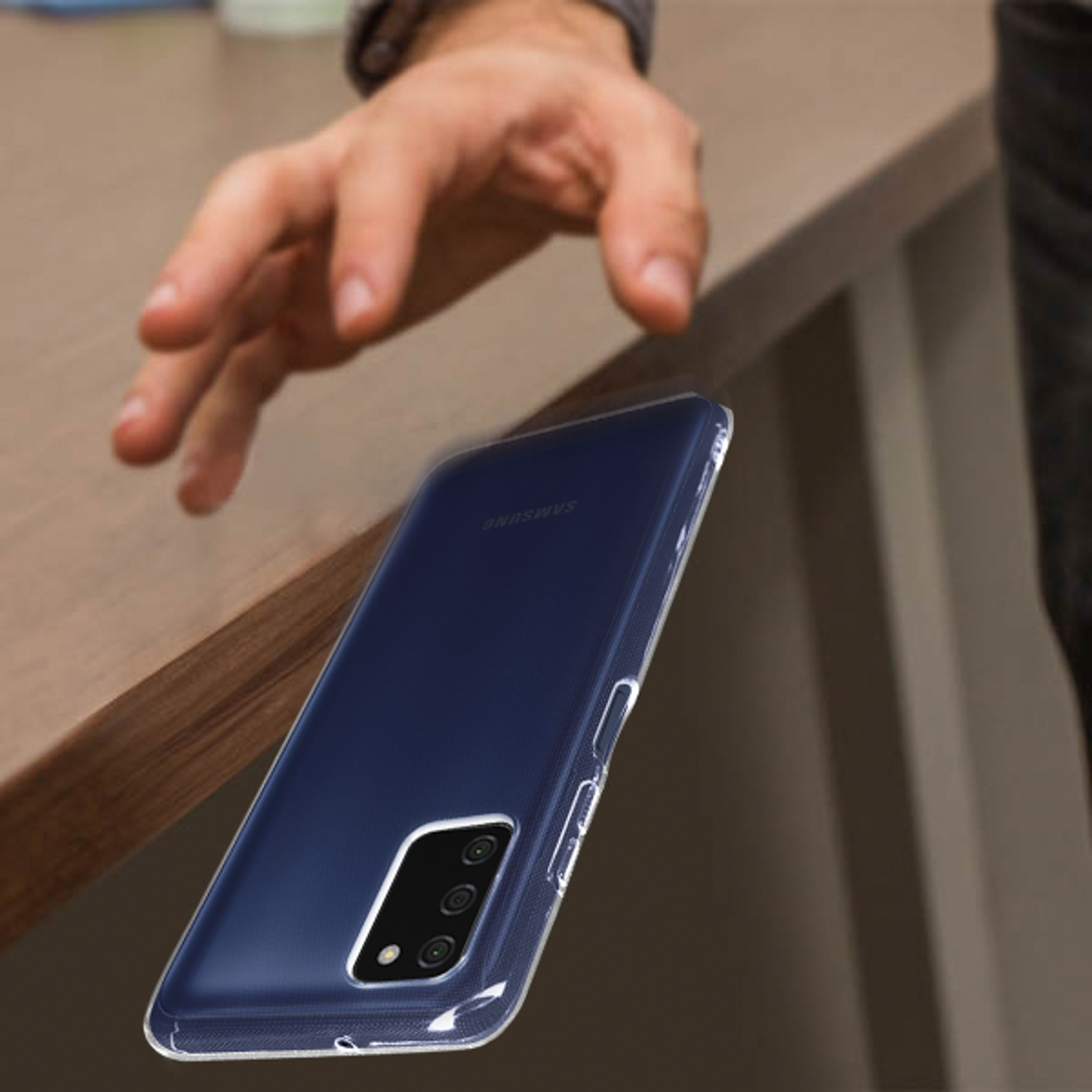Mano sta per toccare un telefono in custodia trasparente su un tavolo. Telefono blu scuro.