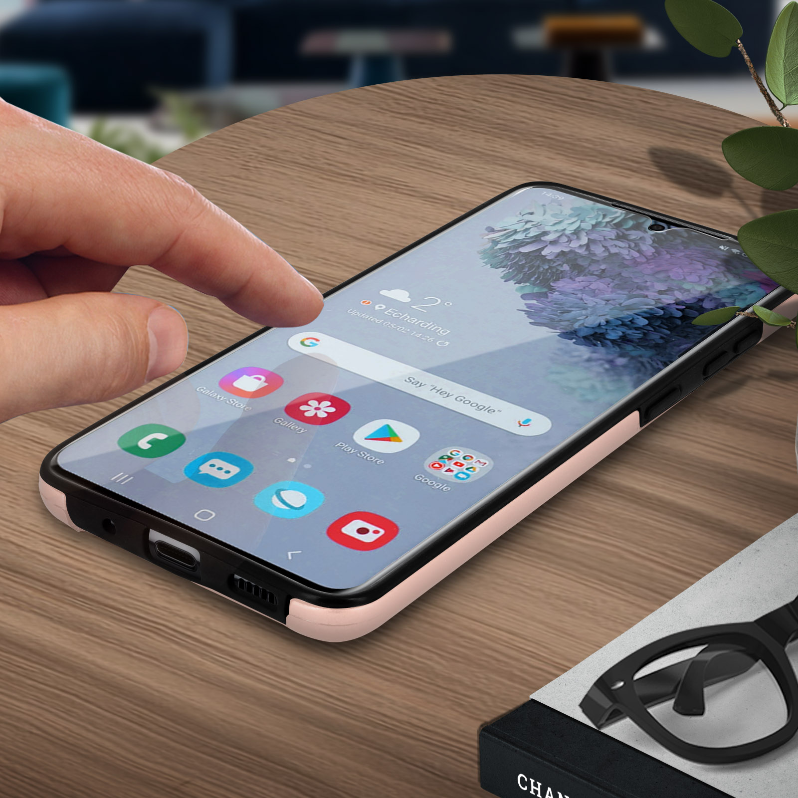 Main touche écran de téléphone avec icônes d'applications. Lunettes et boîte en arrière-plan.