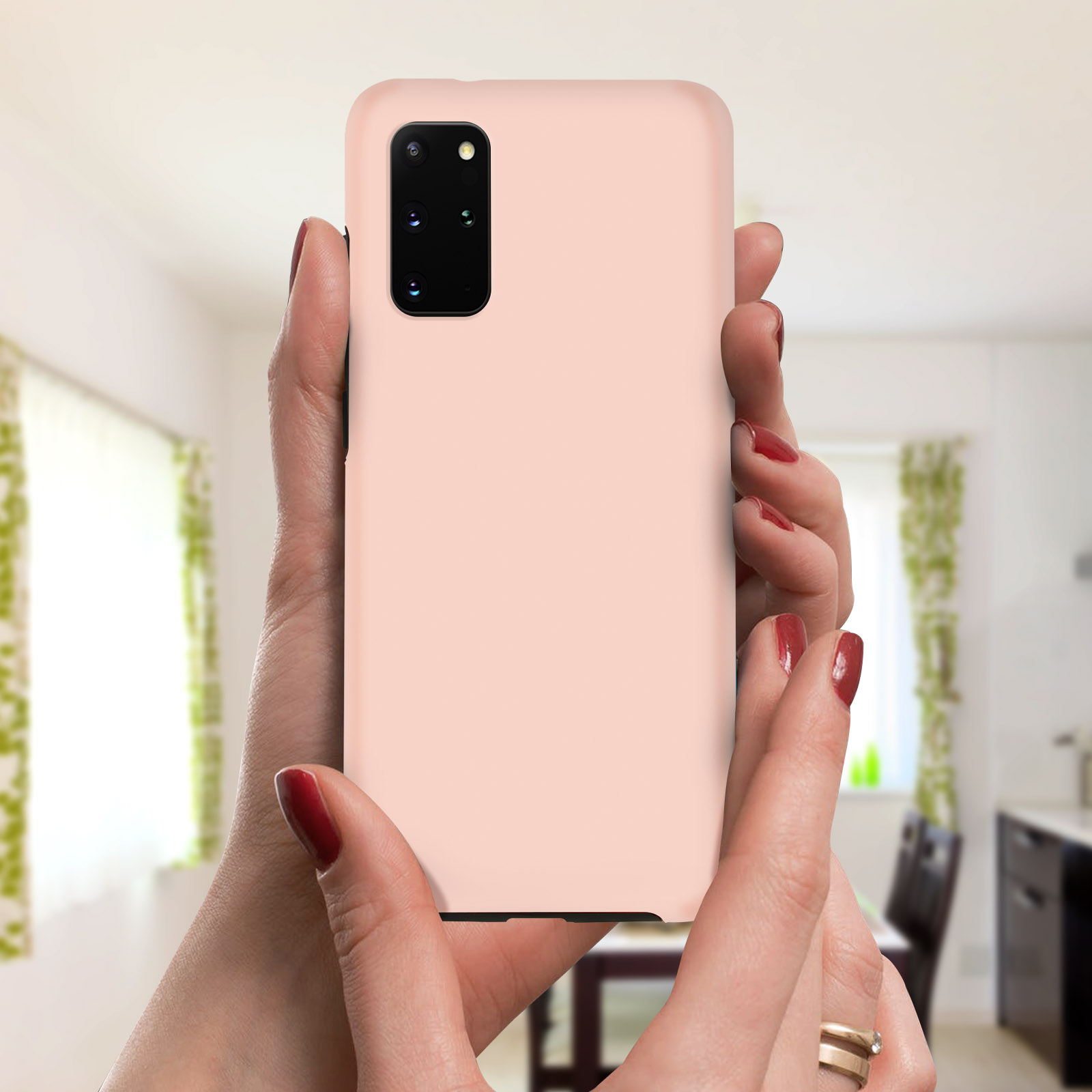 Mains d'une femme tenant une coque rose avec une configuration triple caméra.