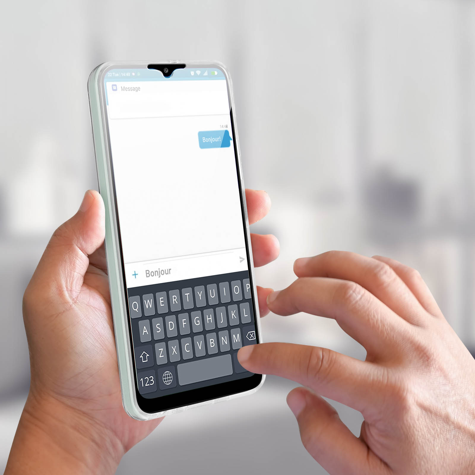 Une personne envoie des SMS sur un téléphone qui est dans un étui. Le message dit 'Bonjour!'