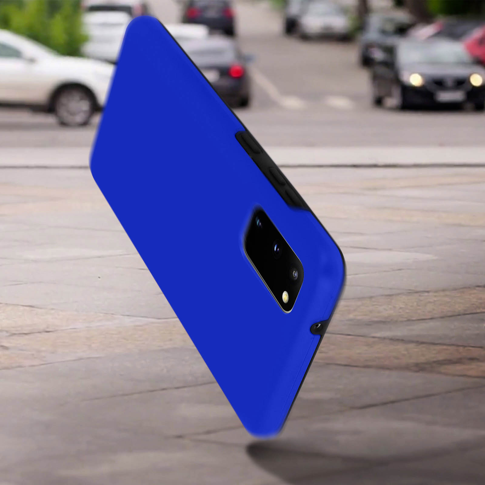 Custodia blu per telefono su una superficie grigia con auto sullo sfondo.