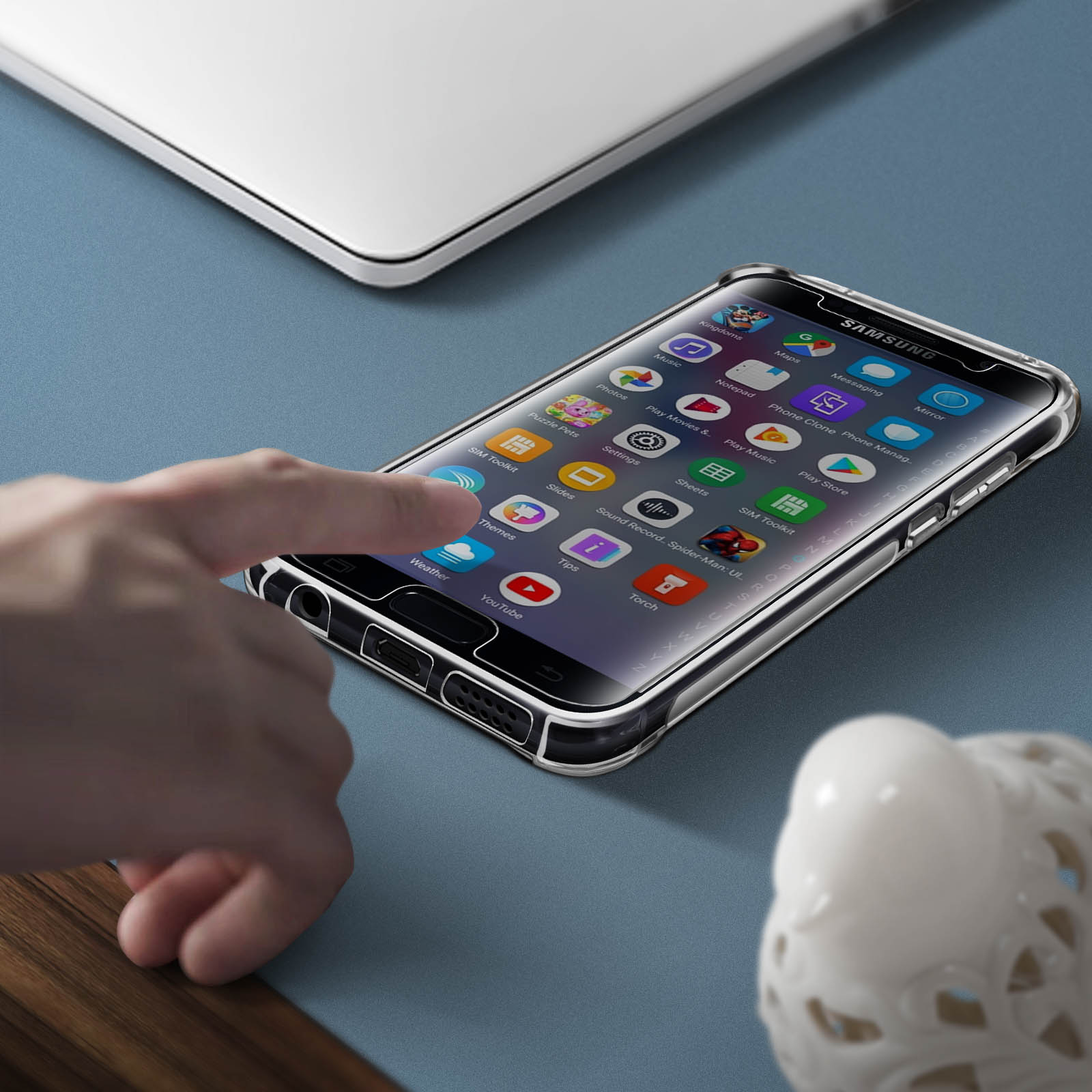 Eine Hand hält ein Smartphone mit einer transparenten Hülle auf einer blauen Oberfläche.