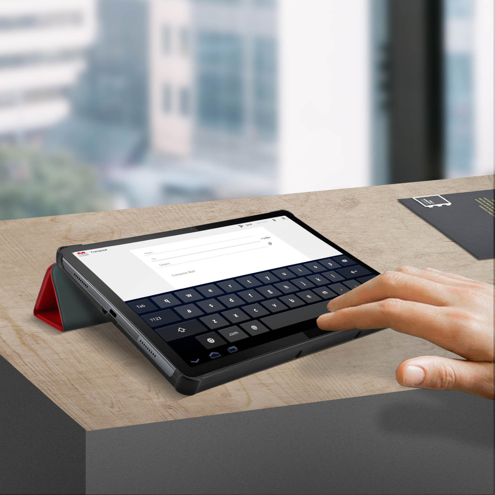 Tablet con tastiera, su un tavolo di legno. Una mano interagisce. Sfondo scuro.