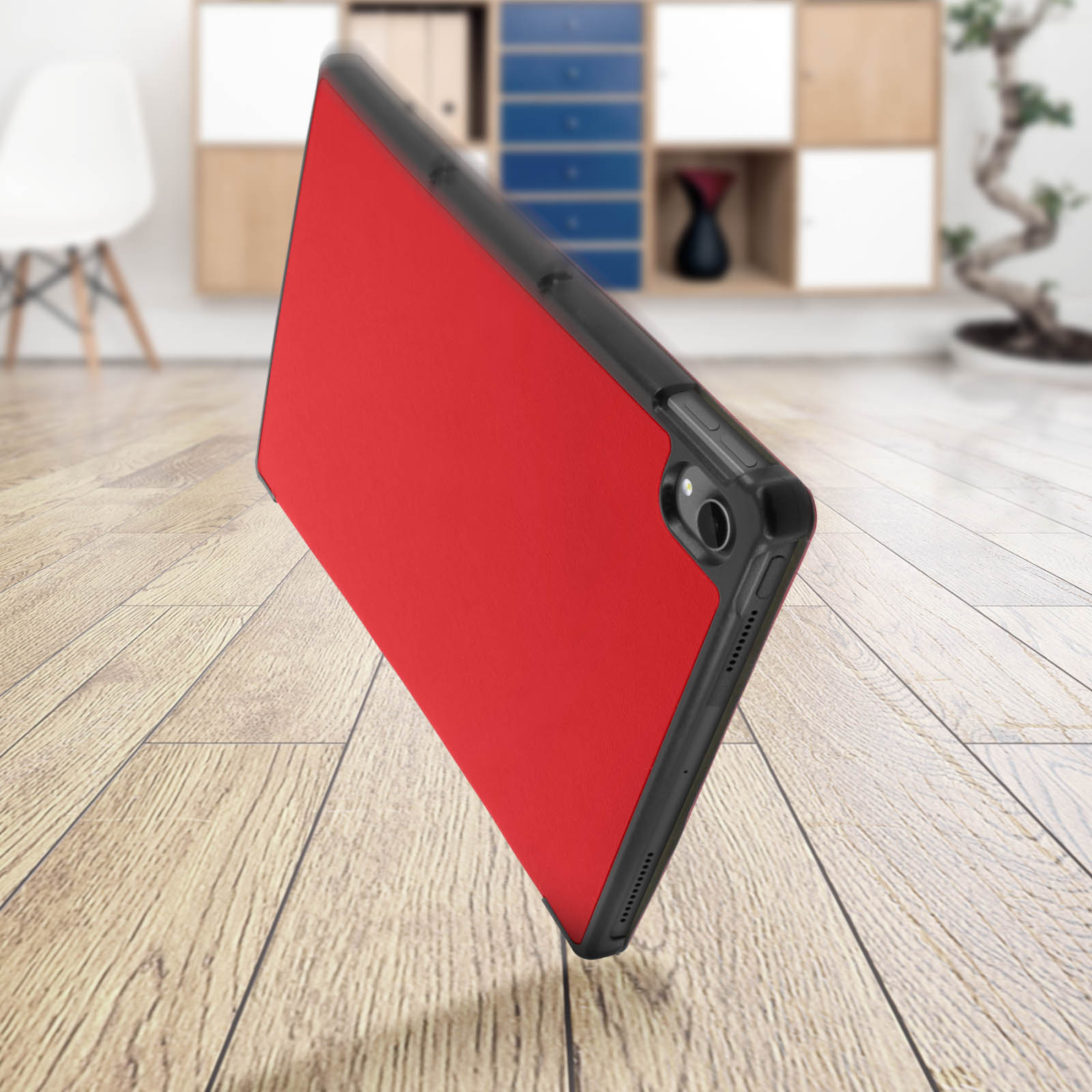 Custodia per tablet rossa con cornice nera, appoggiata a un pavimento in legno. Il tablet è visibile.