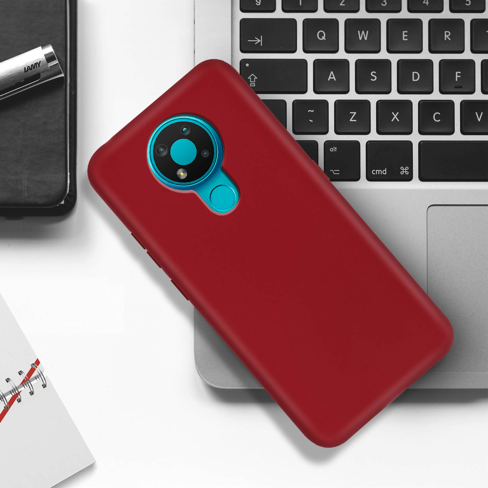 Custodia per telefono rossa su tastiera del laptop, con configurazione a tripla fotocamera e anello blu.
